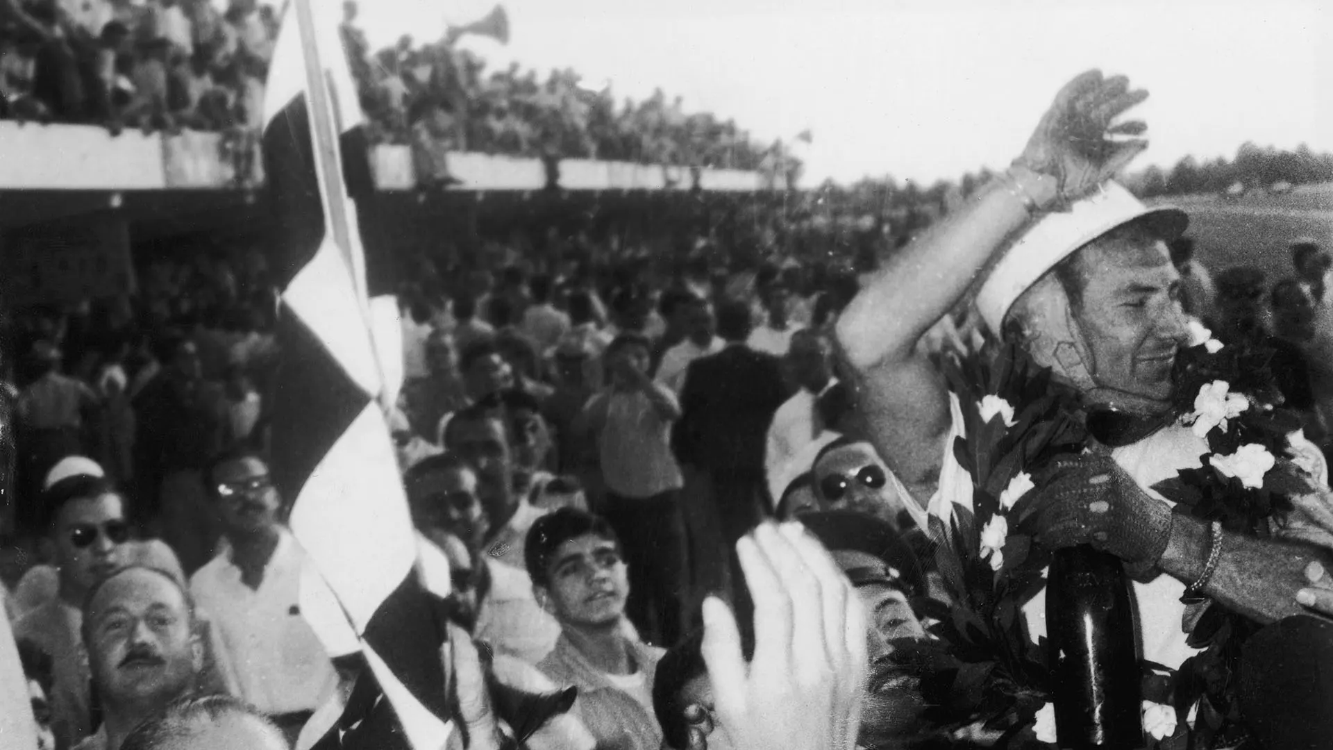 English racing driver Stirling Moss is cheered by the crowd after winning the Argentine Grand Prix