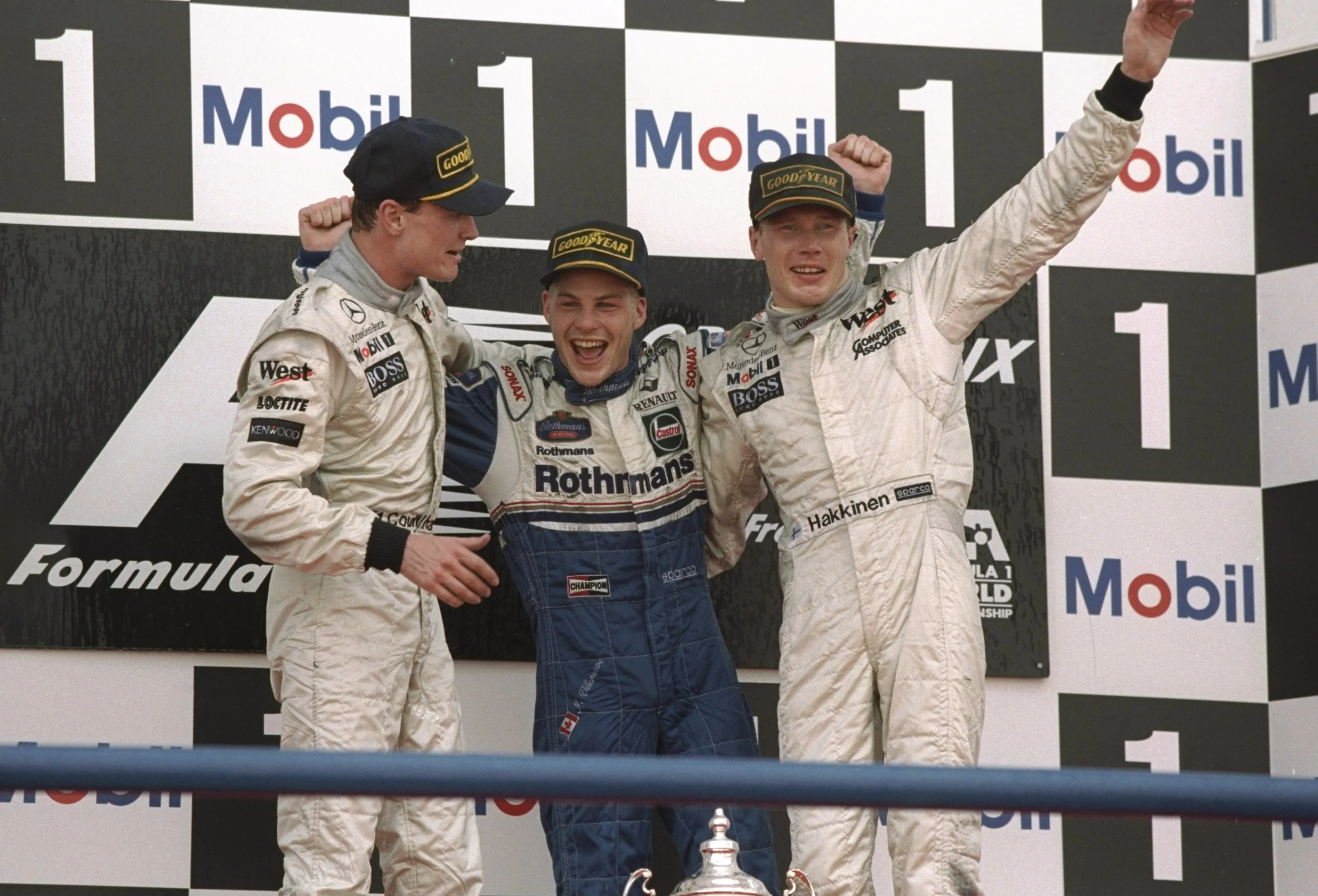 26 Oct 1997:  Williams Renault driver Jacques Villeneuve (centre) of Canada celebrates becoming