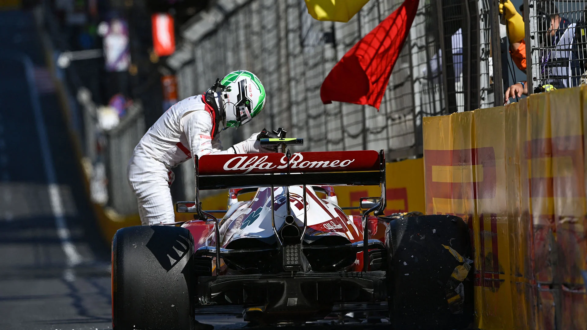 Alfa Romeo's Italian driver Antonio Giovinazzi stands by his car after a crash during the