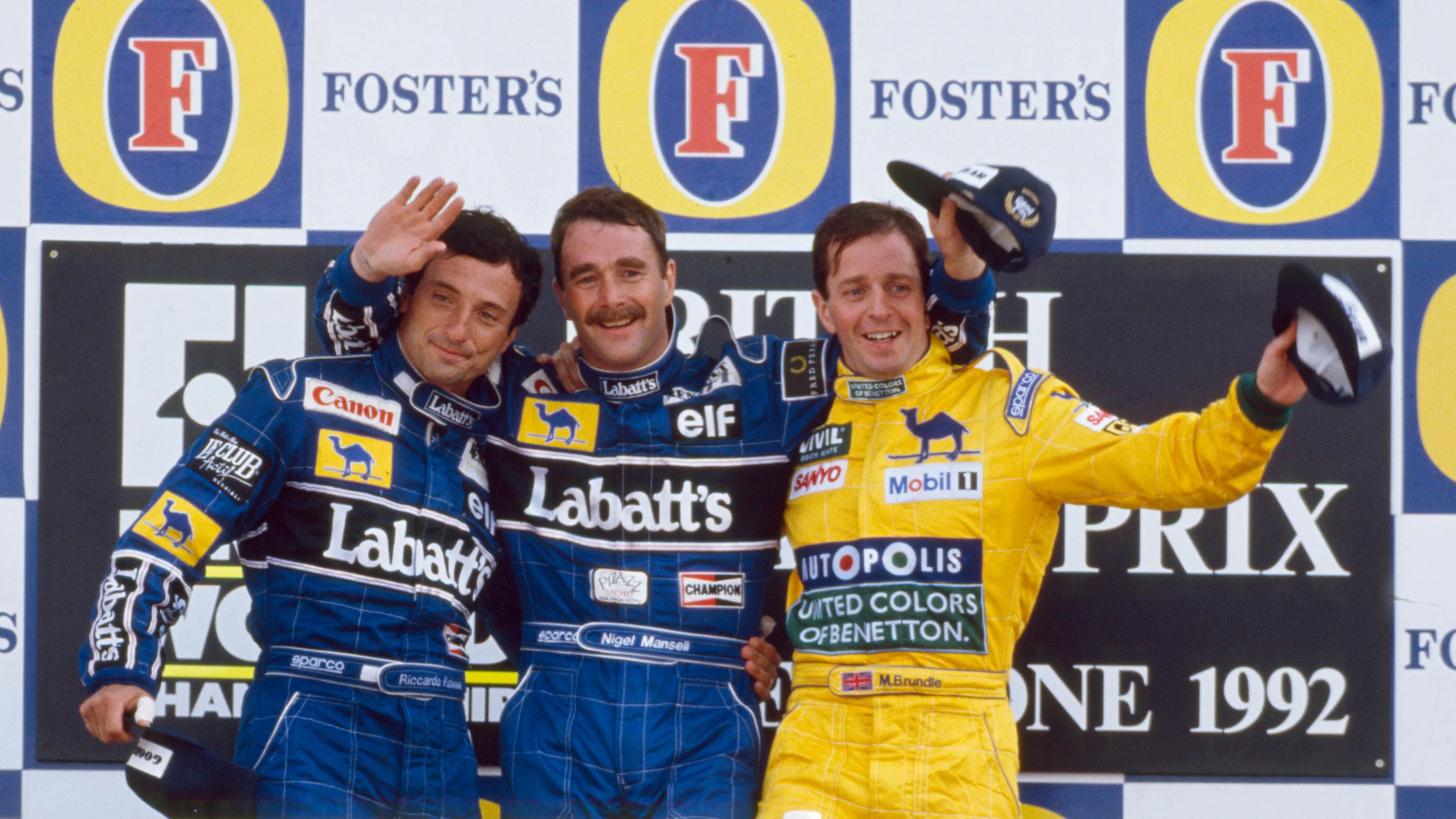 View of the winners of the 1992 British Grand Prix posed together on the podium, with from left,