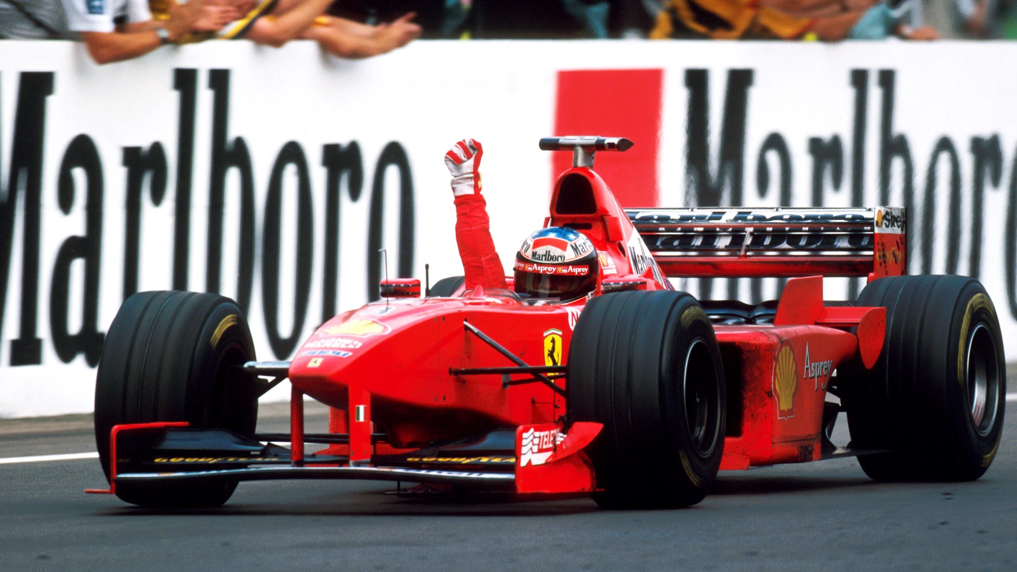 Winner Michael Schumacher (GER), Ferrari F300 celebrates as he crosses the line.\rFormula One World