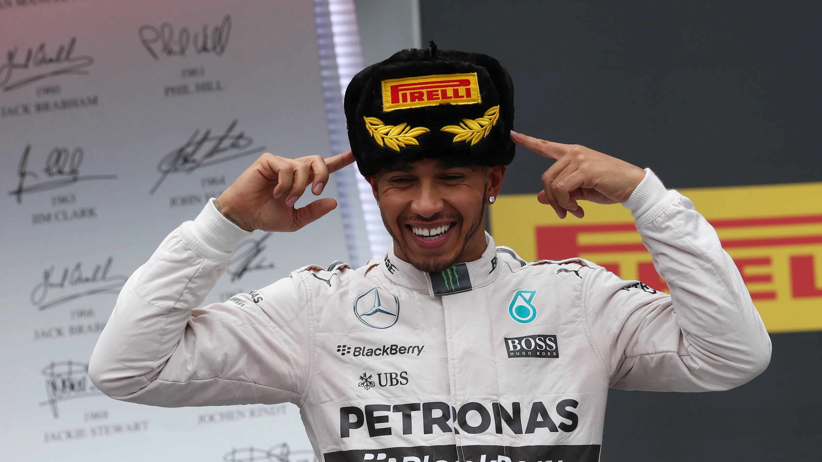 Race winner Lewis Hamilton wears a traditional Russian hat on the podium. © Sutton Motorsport Images
