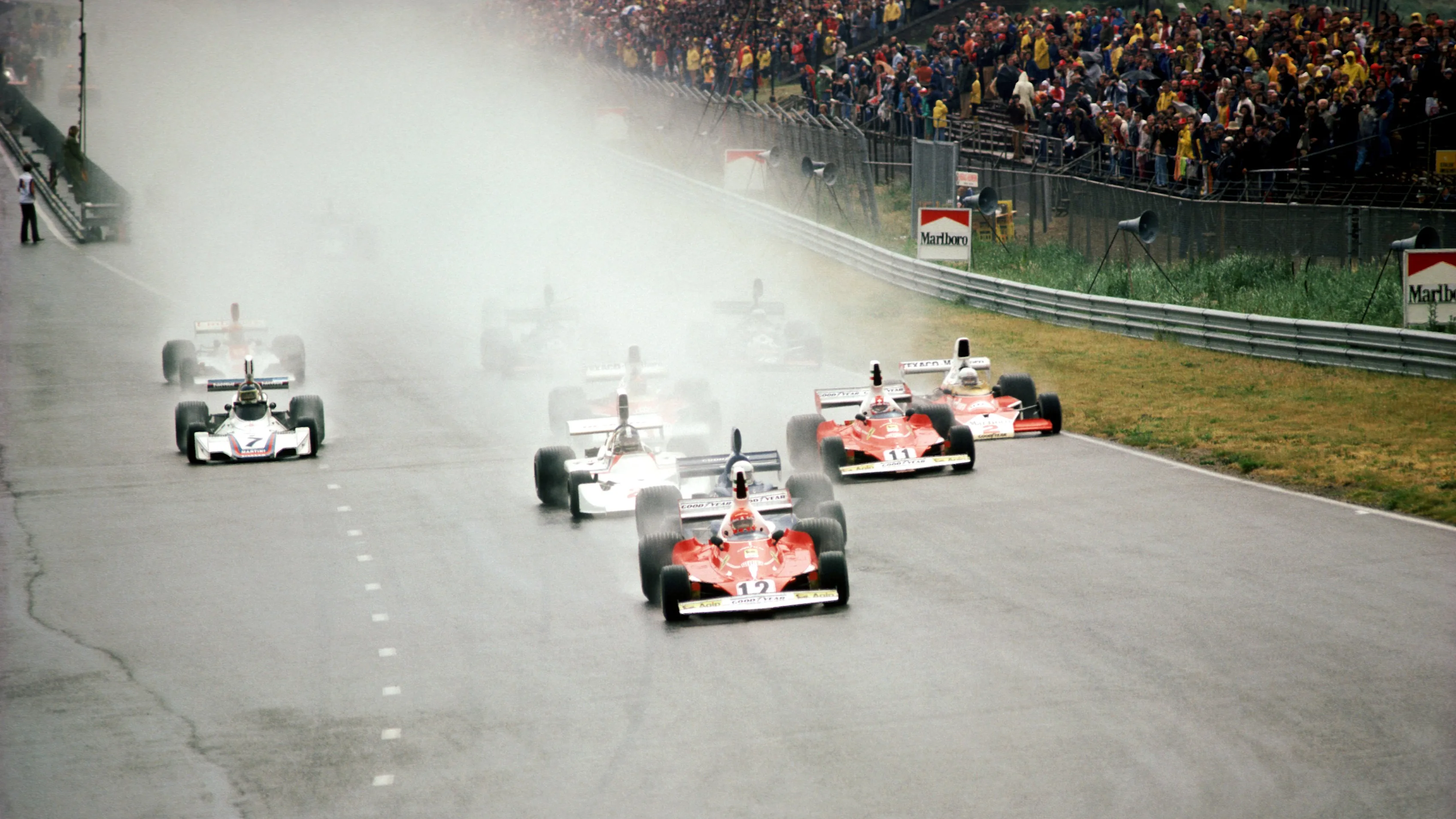 Pole sitter and second place finisher Niki Lauda (AUT) Ferrari 312T leads the field in the wet into