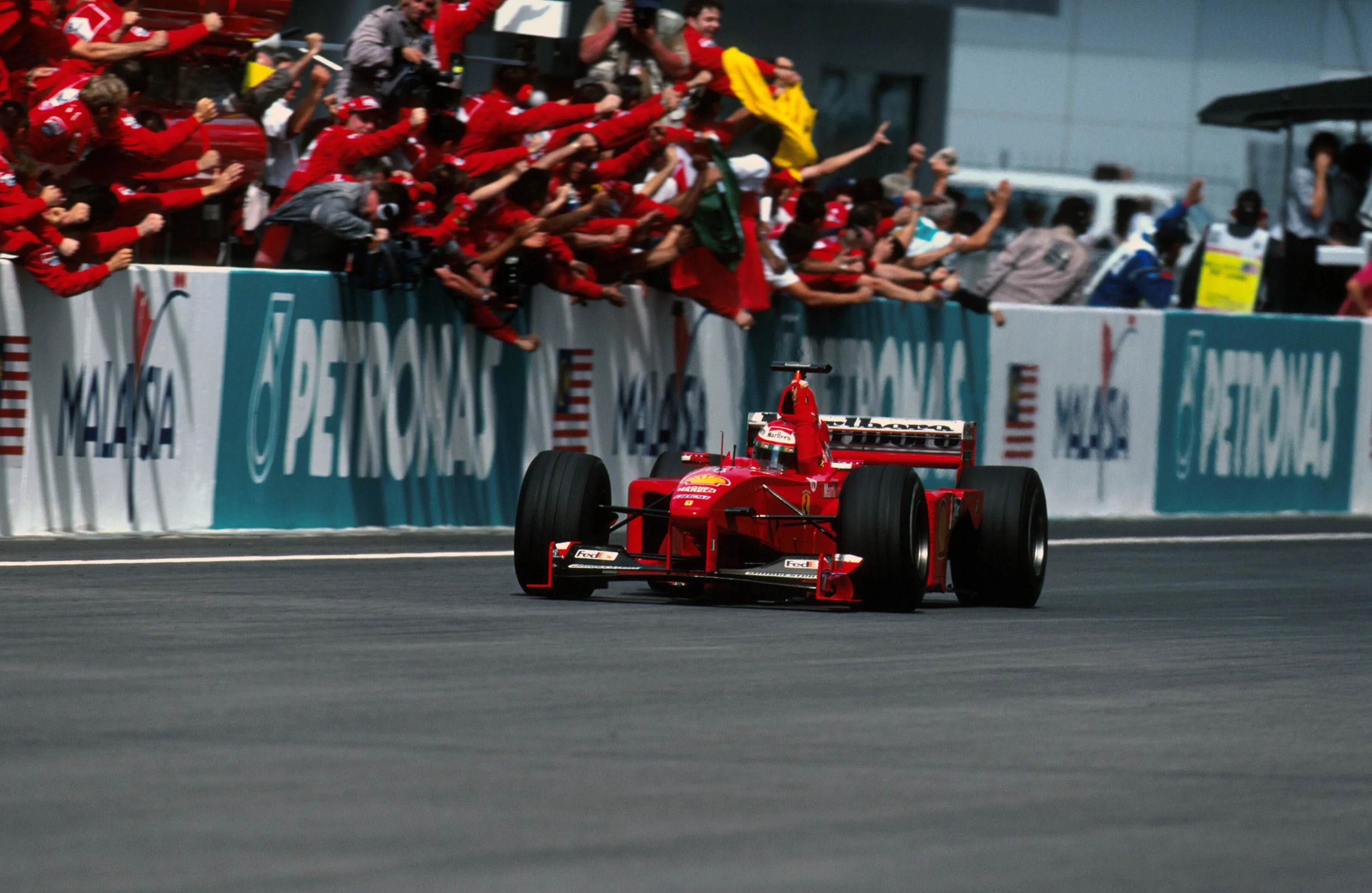Winner Eddie Irvine (GBR) Ferrari F399 passes his pit  Malaysian GP, Sepang, 17 October 1999