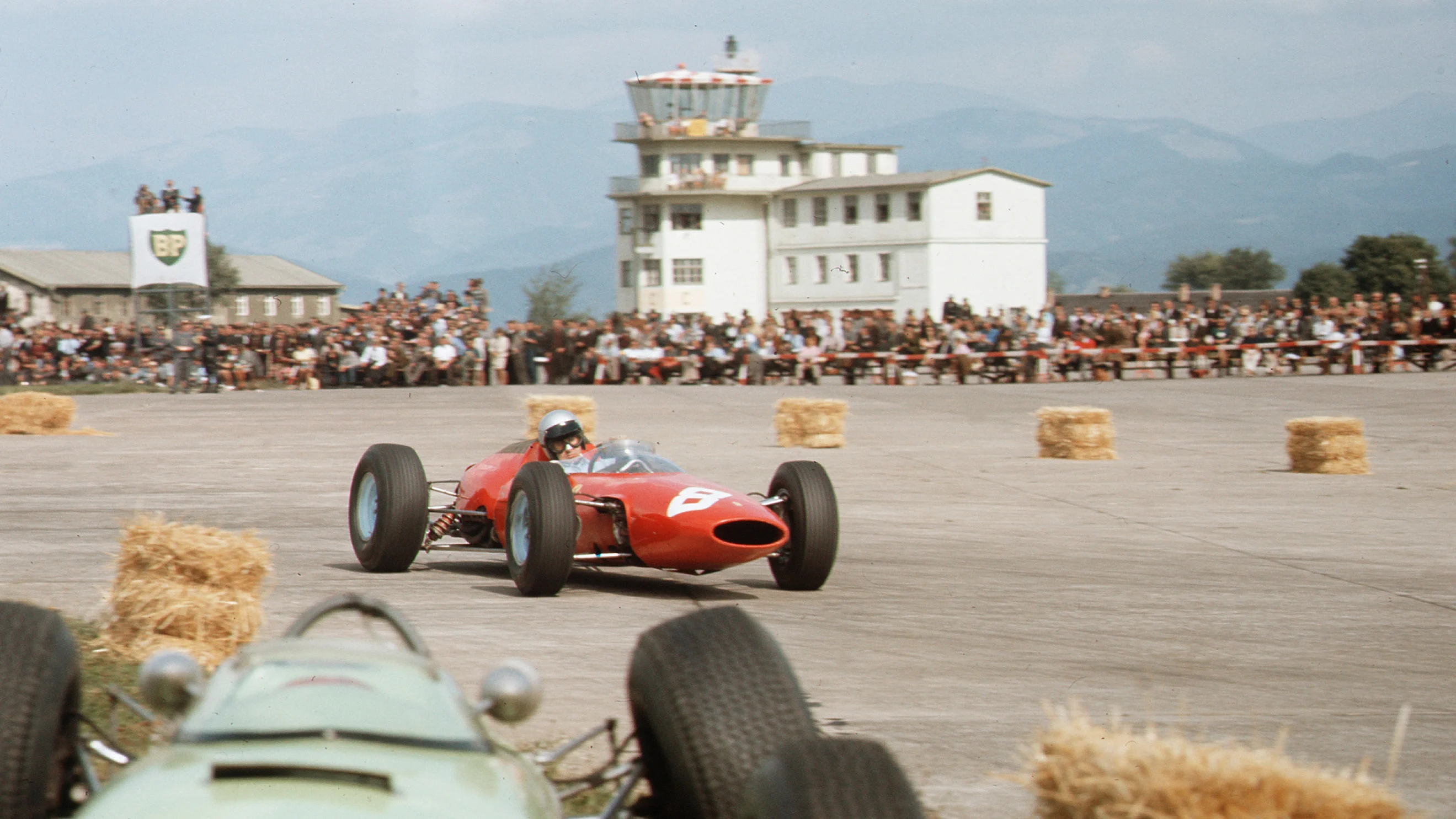 Zeltweg, Austria. 21-23 August 1964. Lorenzo Bandini (Ferrari 156) passes the crashed BRP 1-BRM