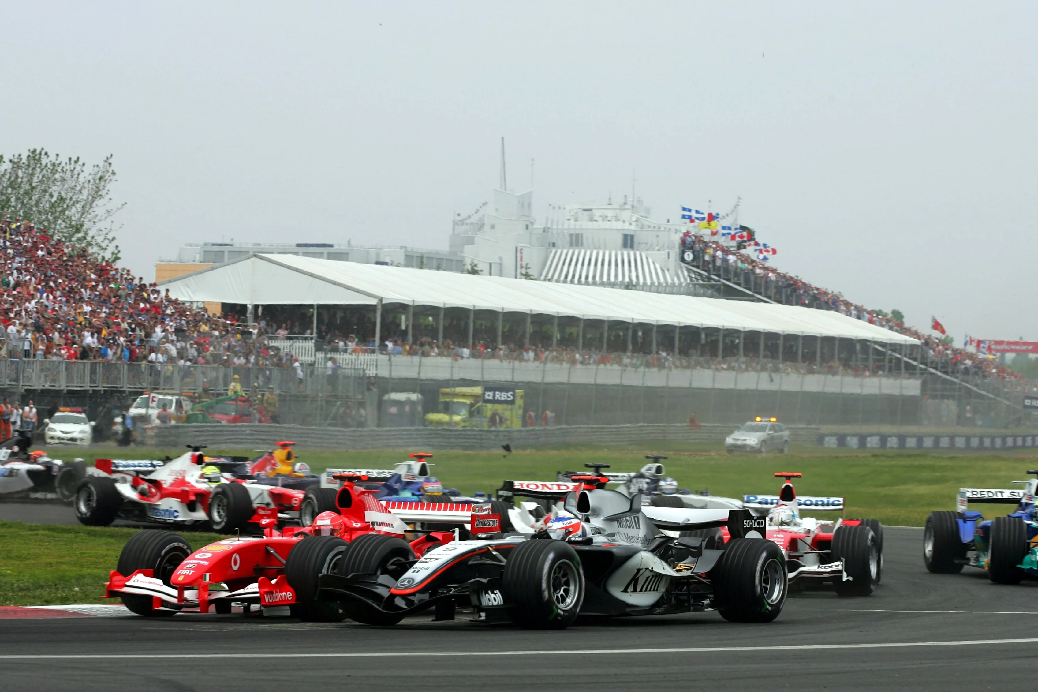 Kimi Raikkonen (FIN) McLaren Mercedes MP4/20 goes around the out side of Michael Schumacher (GER)