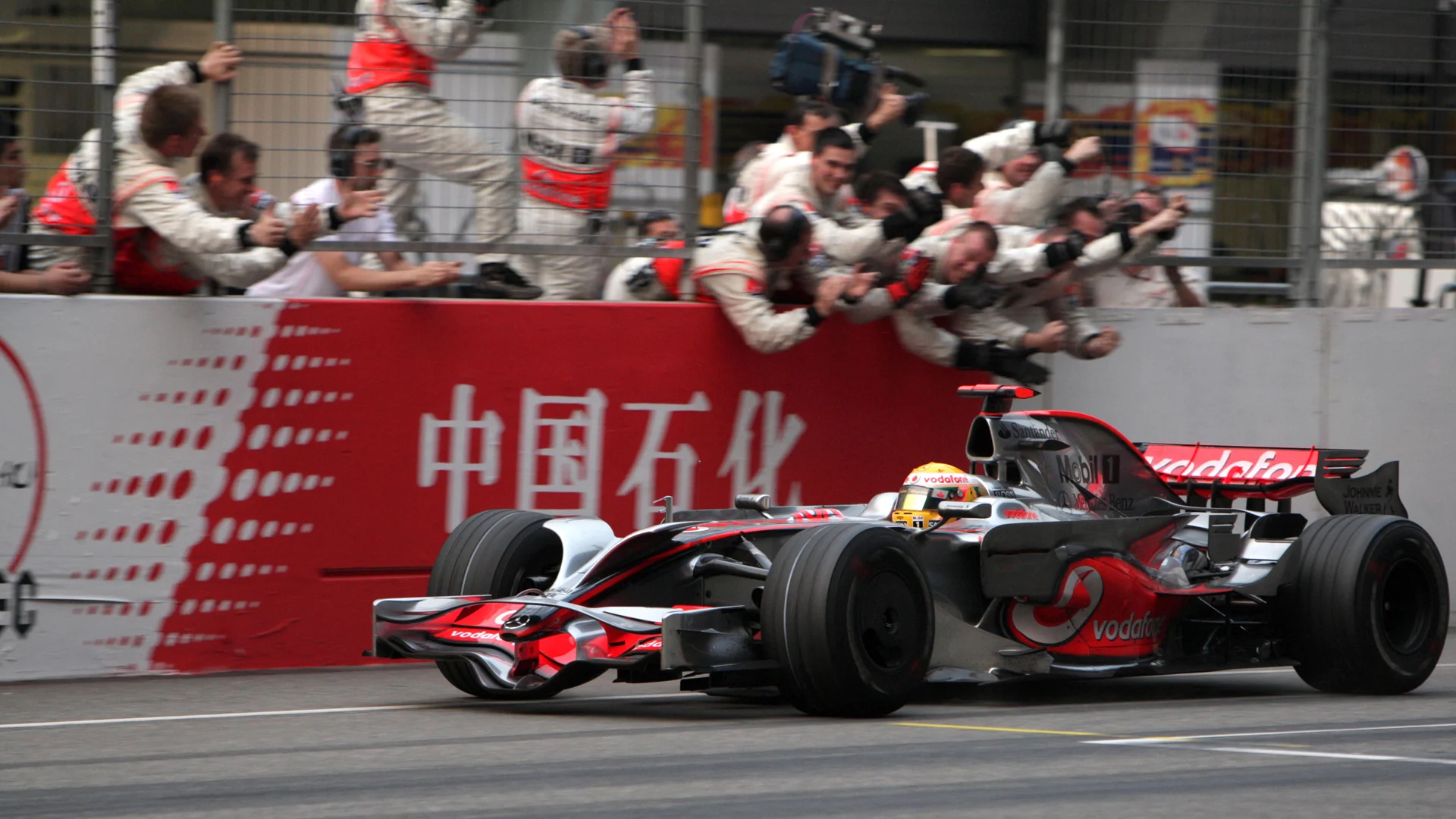 Lewis Hamilton (GBR) McLaren Mercedes MP4/23 passes his team after winning the race Formula One