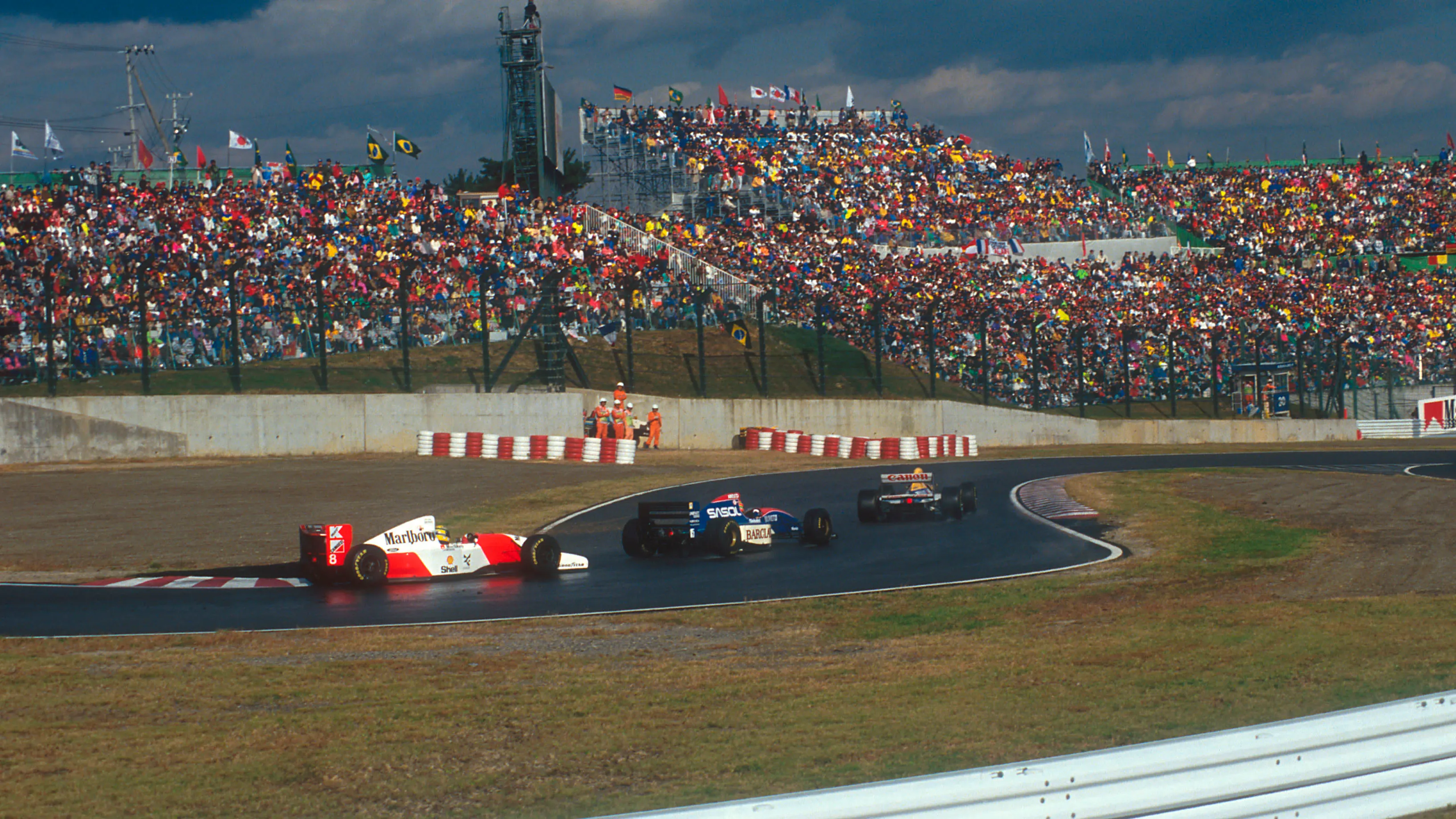 Eddie Irvine (middle car) unlapped himself from Ayrton Senna (rear car) going into Suzuka's famous chicane. © LAT Photographic