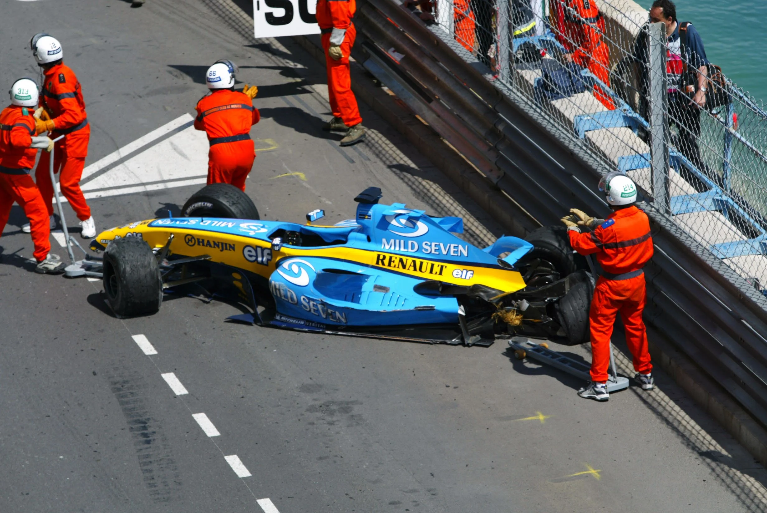 The Renault R24 of Fernando Alonso (ESP) is recovered by marshalls after crashing out of the