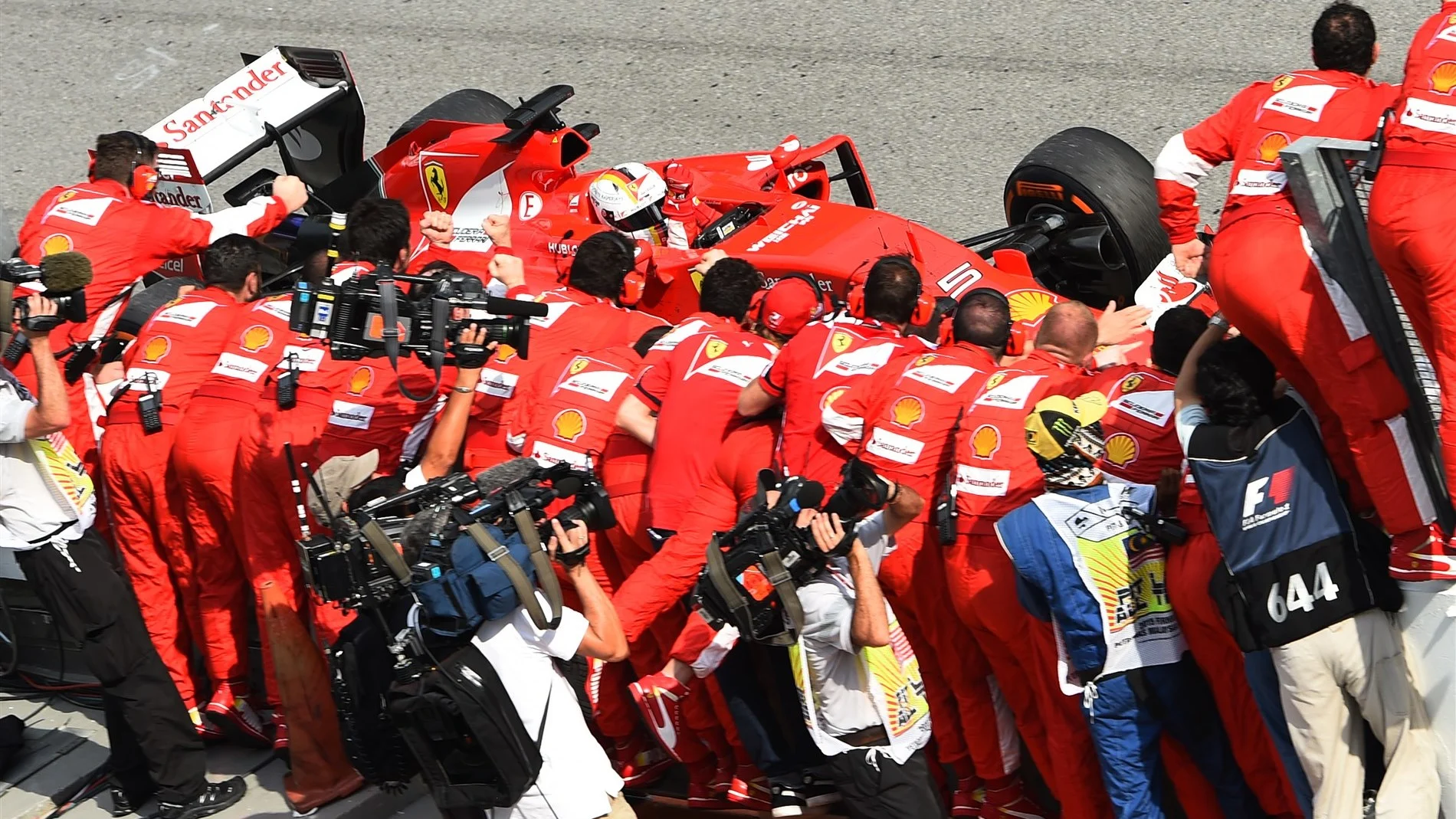 Sebastian Vettel (GER) Ferrari SF15-T crosses the line and passes his team saluting them after