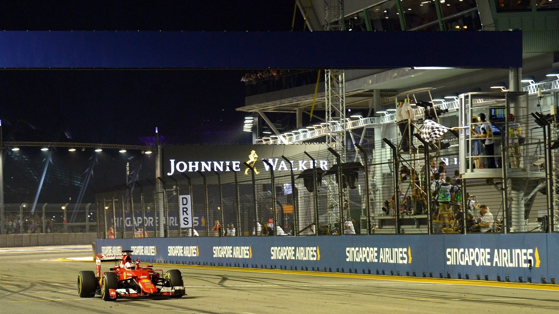 Race winner Sebastian Vettel (GER) Ferrari SF15-T crosses the line and takes the chequered flag at