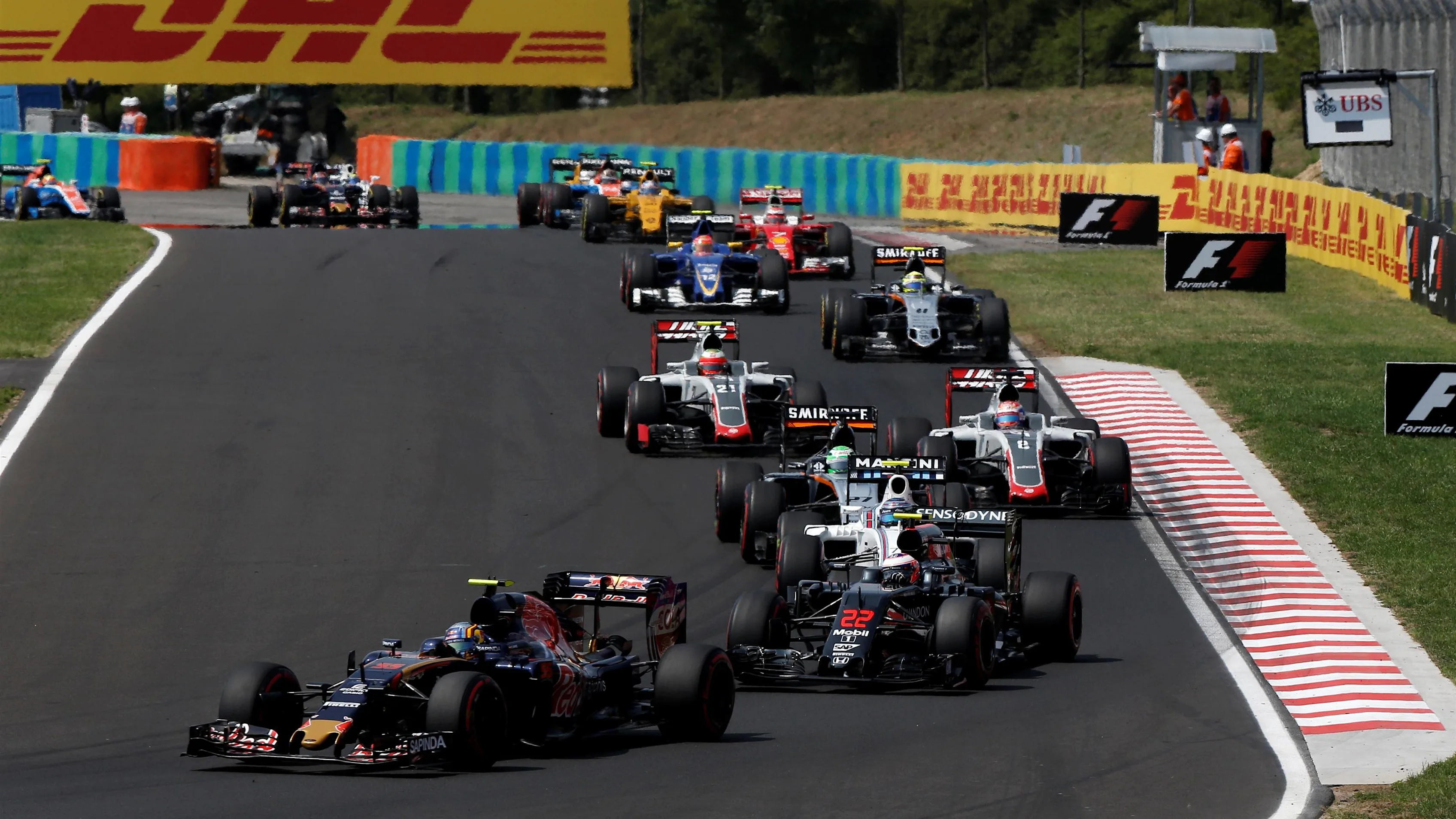 Carlos Sainz (ESP) Scuderia Toro Rosso STR11 and Jenson Button (GBR) McLaren MP4-31 at the start of the race at Formula One World Championship, Rd11, Hungarian Grand Prix, Race, Hungaroring, Hungary, Sunday 24 July 2016. © Sutton Images