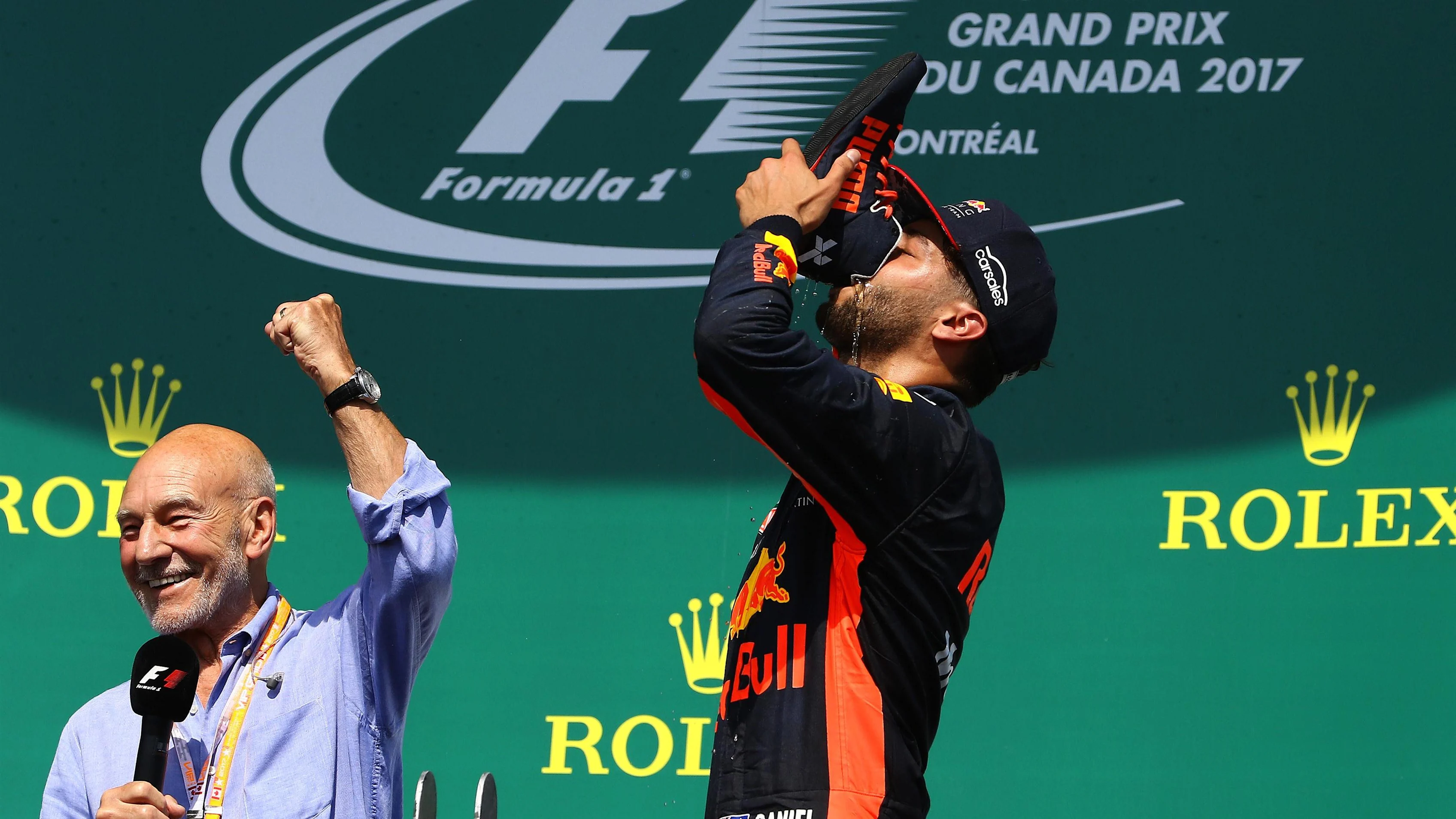 Daniel Ricciardo (AUS) Red Bull Racing does a shoey on the podium watched by Patrick Stewart (GBR)