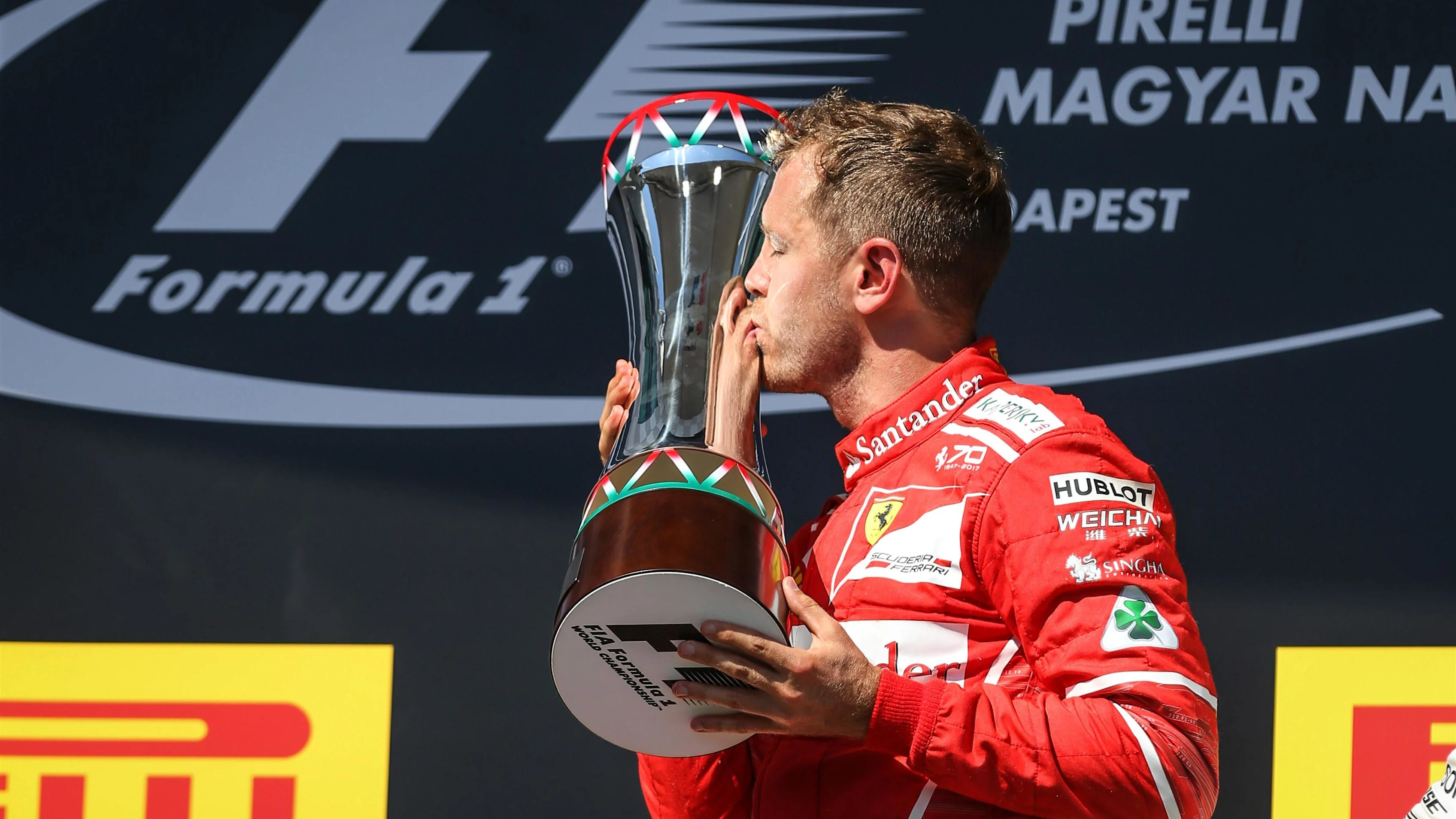 race winner Sebastian Vettel (GER) Ferrari celebrates on the podium and kisses the trophy at Formula One World Championship, Rd11, Hungarian Grand Prix, Race, Hungaroring, Hungary, Sunday 30 July 2017. © Sutton Images