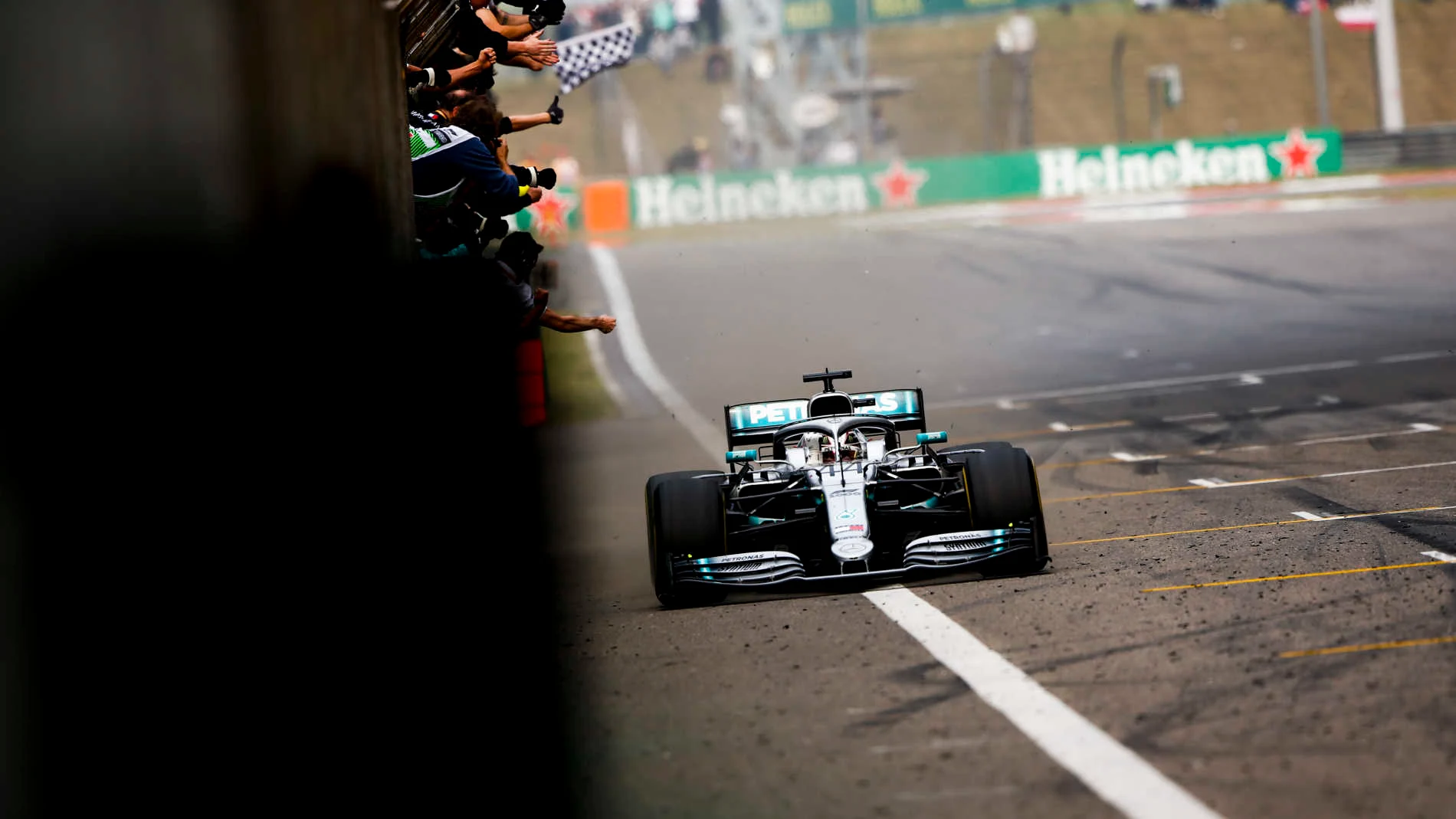 SHANGHAI INTERNATIONAL CIRCUIT, CHINA - APRIL 14: Lewis Hamilton, Mercedes AMG F1 W10, 1st position, crosses the line for victory to the delight of his team on the pit wall during the Chinese GP at Shanghai International Circuit on April 14, 2019 in Shanghai International Circuit, China. (Photo by Andy Hone / LAT Images)