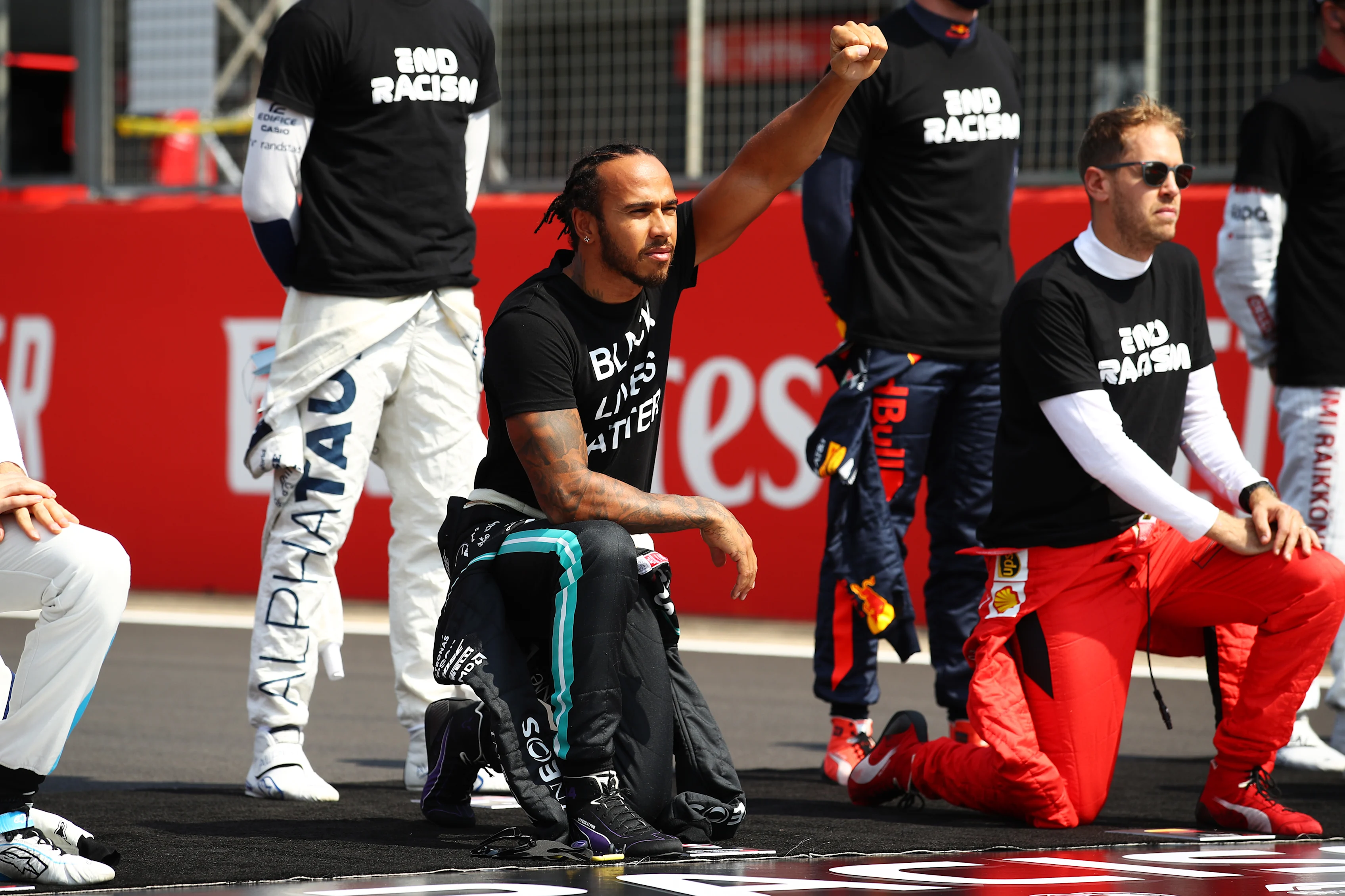 NORTHAMPTON, ENGLAND - AUGUST 09: Lewis Hamilton of Great Britain and Mercedes GP takes a knee on