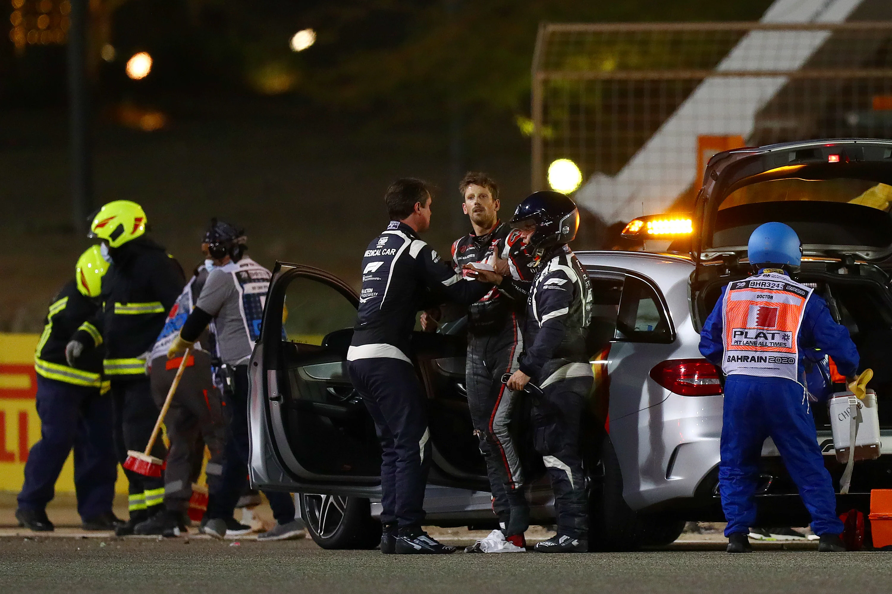BAHRAIN, BAHRAIN - NOVEMBER 29: Romain Grosjean of France and Haas F1 is pictured being helped into