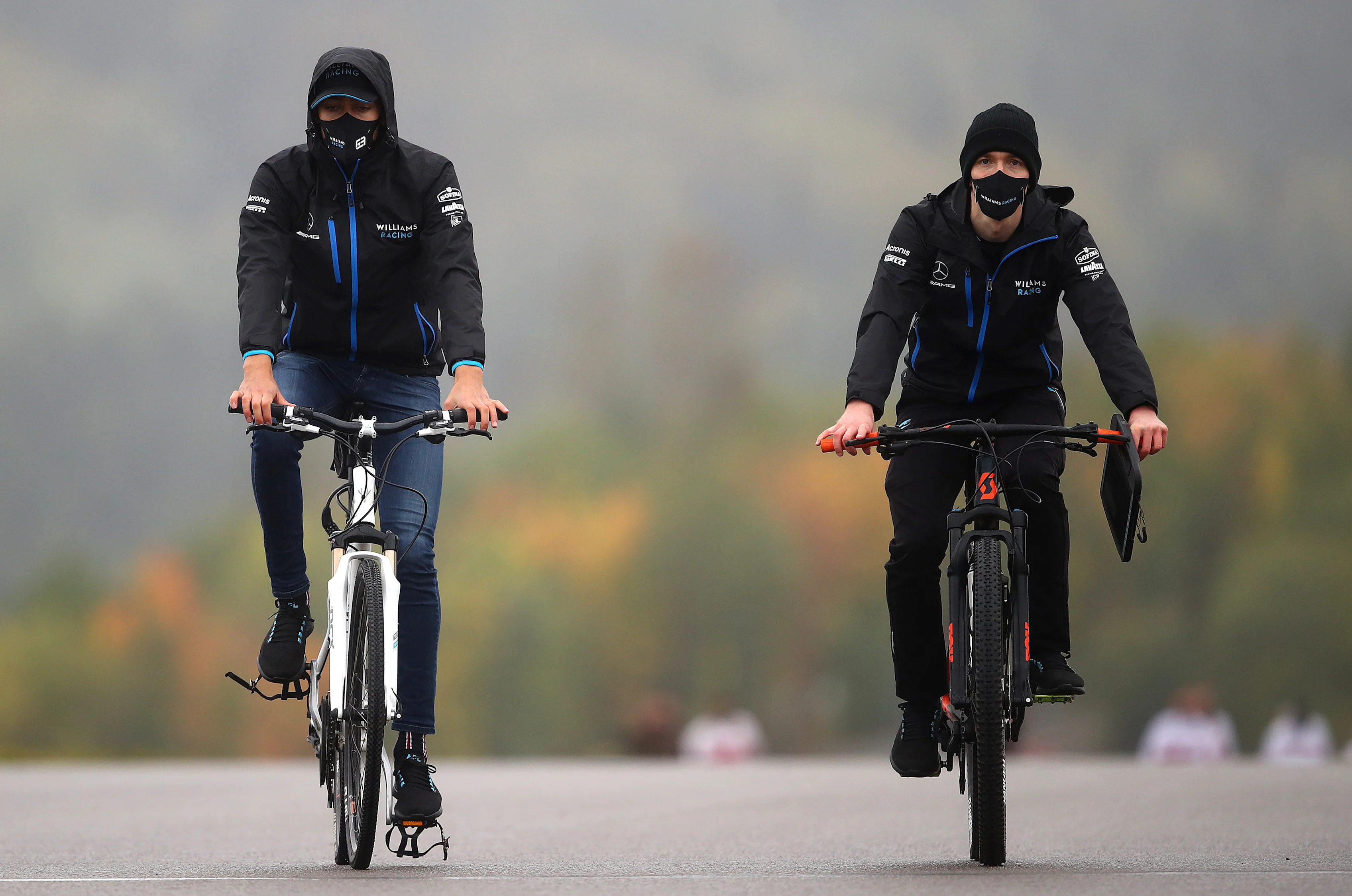 NUERBURG, GERMANY - OCTOBER 08: George Russell of Great Britain and Williams (left) cycles the