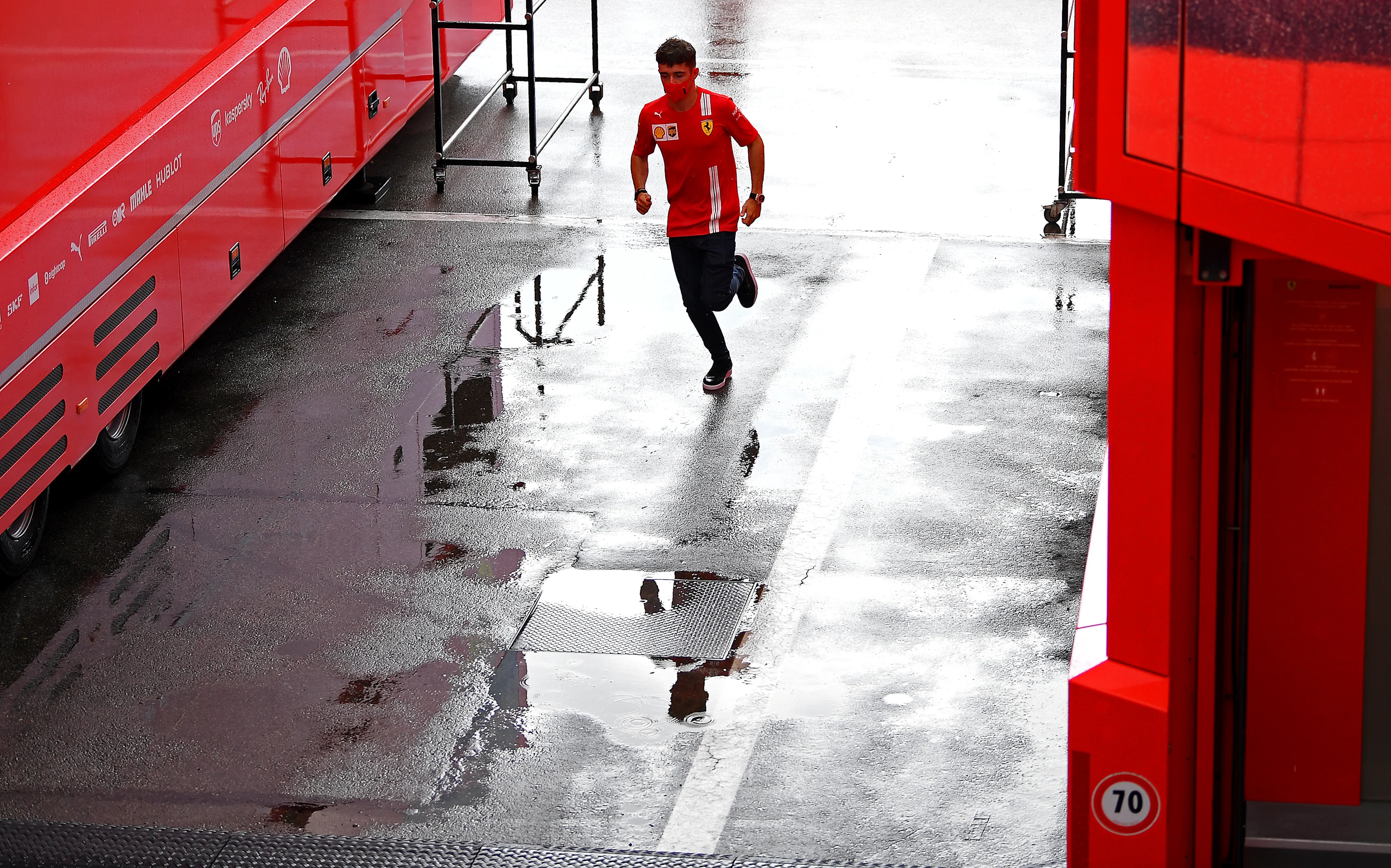 BARCELONA, SPAIN - AUGUST 13: Charles Leclerc of Monaco and Ferrari runs through the paddock during