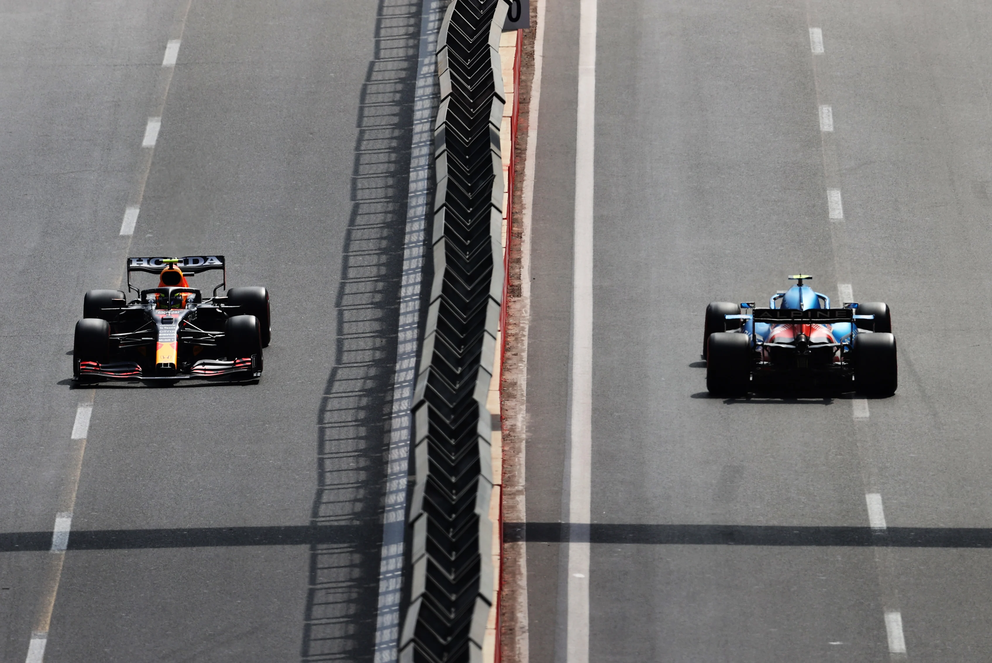 BAKU, AZERBAIJAN - JUNE 06: Sergio Perez of Mexico driving the (11) Red Bull Racing RB16B Honda and Esteban Ocon of France driving the (31) Alpine A521 Renault on their way to the grid before the F1 Grand Prix of Azerbaijan at Baku City Circuit on June 06, 2021 in Baku, Azerbaijan. (Photo by Clive Rose/Getty Images)