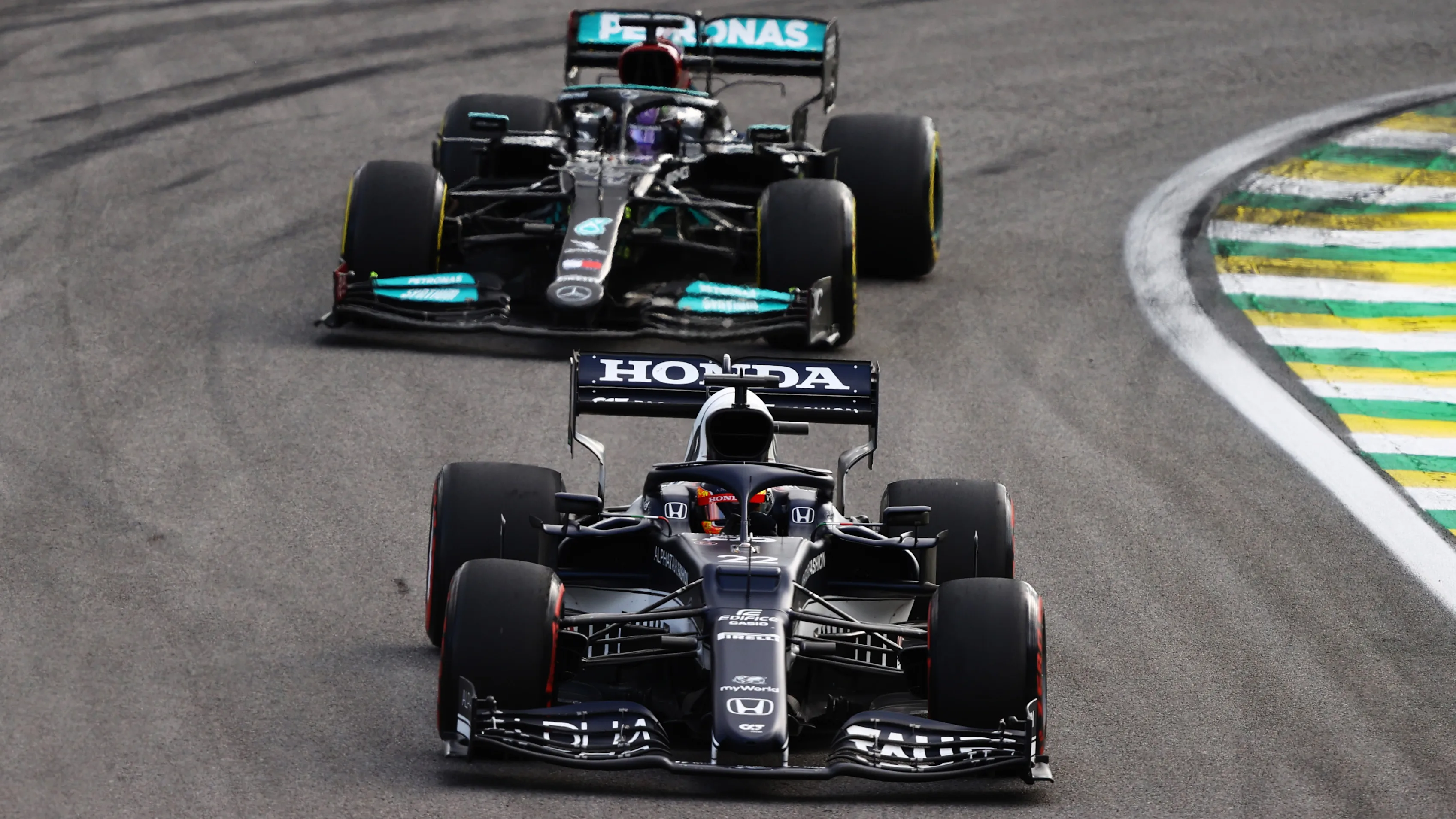 SAO PAULO, BRAZIL - NOVEMBER 13: Yuki Tsunoda of Japan driving the (22) Scuderia AlphaTauri AT02 Honda leads Lewis Hamilton of Great Britain driving the (44) Mercedes AMG Petronas F1 Team Mercedes W12 during the sprint ahead of the F1 Grand Prix of Brazil at Autodromo Jose Carlos Pace on November 13, 2021 in Sao Paulo, Brazil. (Photo by Bryn Lennon - Formula 1/Formula 1 via Getty Images)