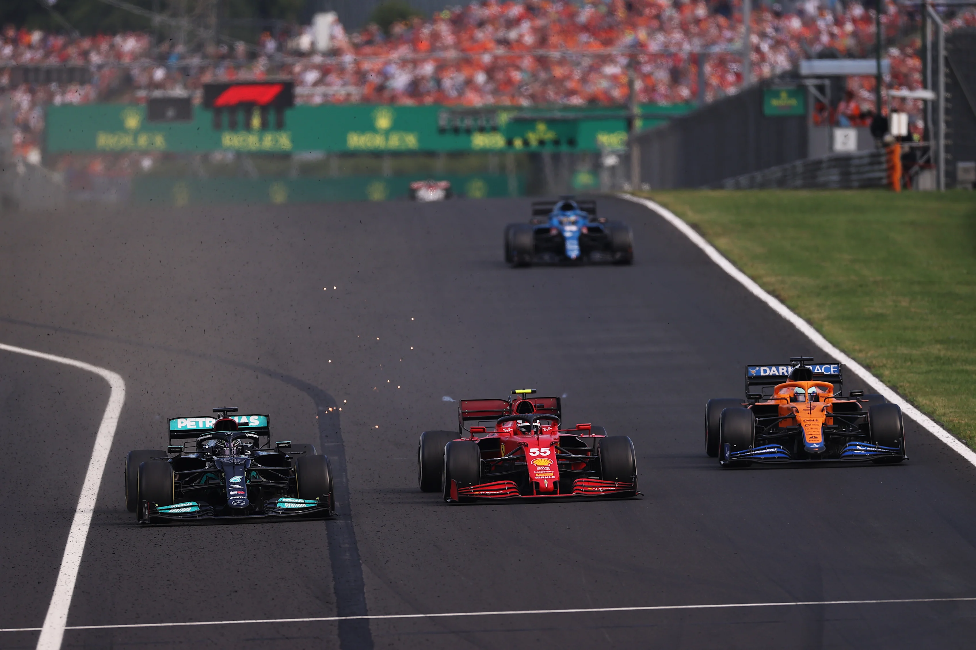 BUDAPEST, HUNGARY - AUGUST 01: Lewis Hamilton of Great Britain driving the (44) Mercedes AMG Petronas F1 Team Mercedes W12 overtakes Carlos Sainz of Spain driving the (55) Scuderia Ferrari SF21 for third place during the F1 Grand Prix of Hungary at Hungaroring on August 01, 2021 in Budapest, Hungary. (Photo by Lars Baron/Getty Images)