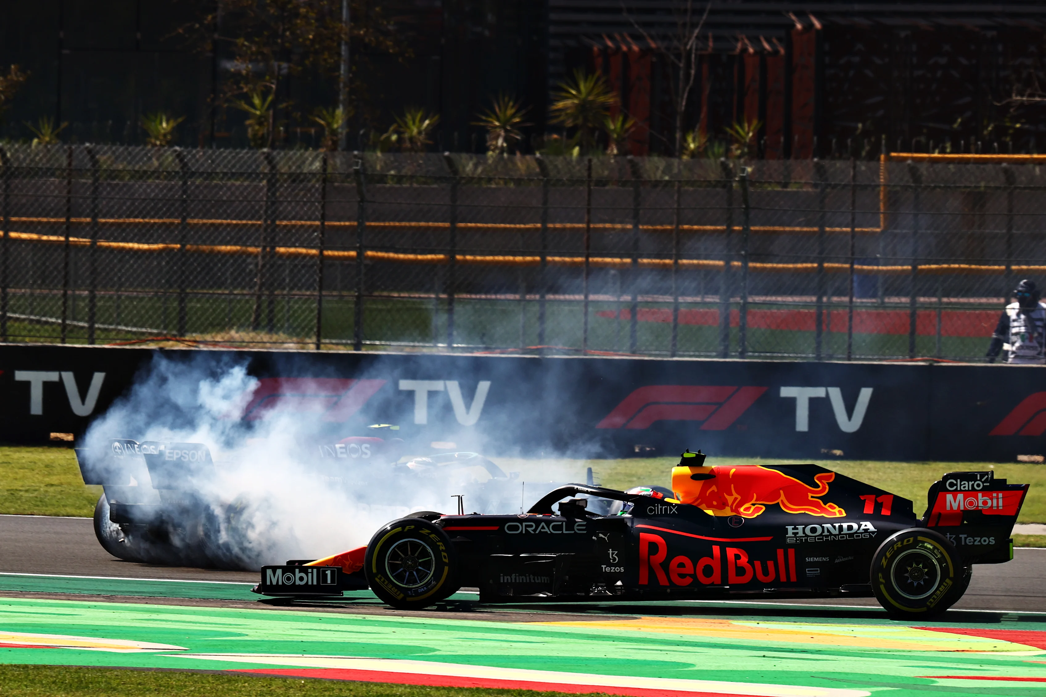 MEXICO CITY, MEXICO - NOVEMBER 07: Sergio Perez of Mexico driving the (11) Red Bull Racing RB16B Honda passes Valtteri Bottas of Finland driving the (77) Mercedes AMG Petronas F1 Team Mercedes W12 as he spins during the F1 Grand Prix of Mexico at Autodromo Hermanos Rodriguez on November 07, 2021 in Mexico City, Mexico. (Photo by Mark Thompson/Getty Images)