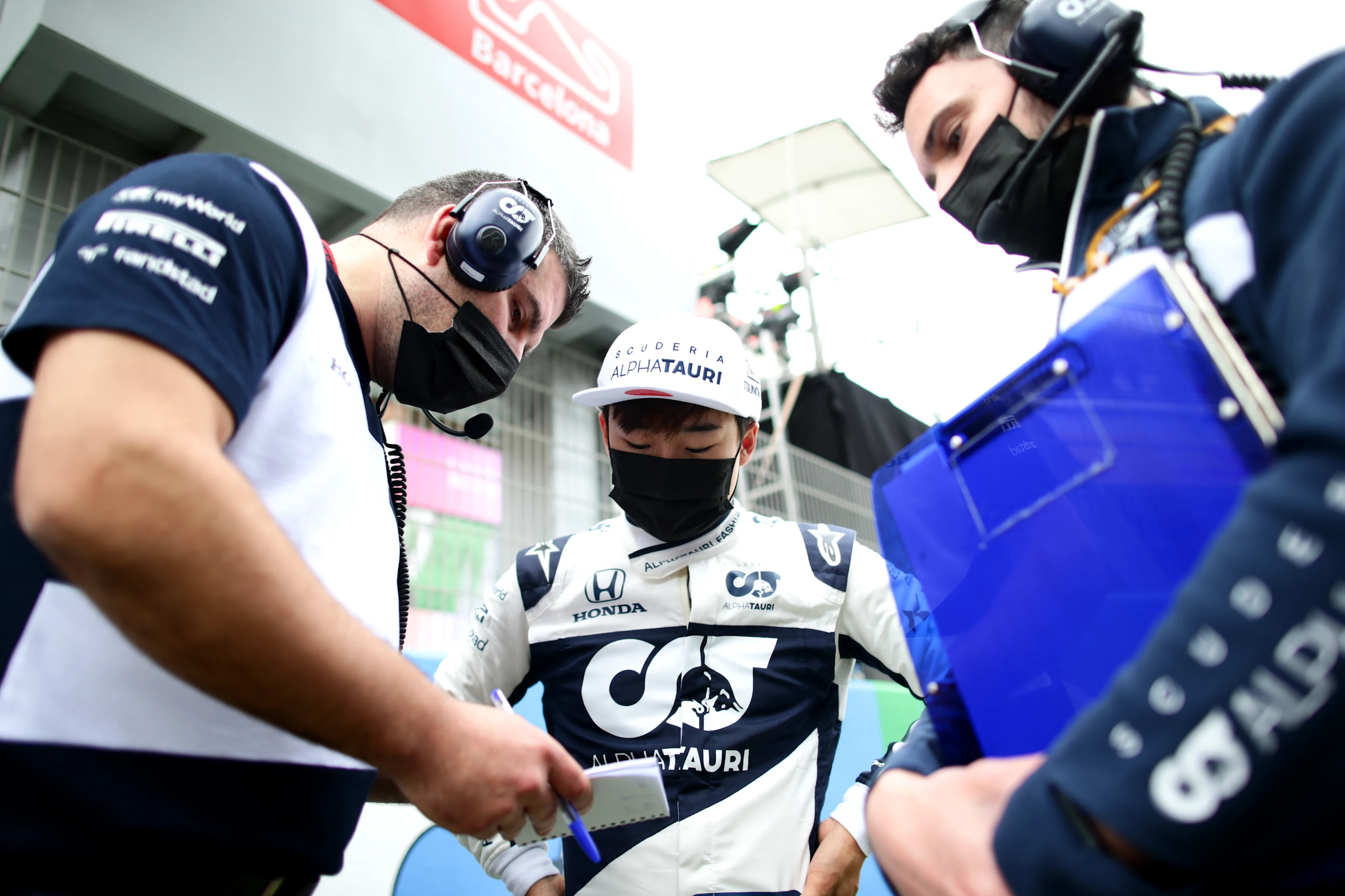 BARCELONA, SPAIN - MAY 09: Yuki Tsunoda of Japan and Scuderia AlphaTauri talks with team members on