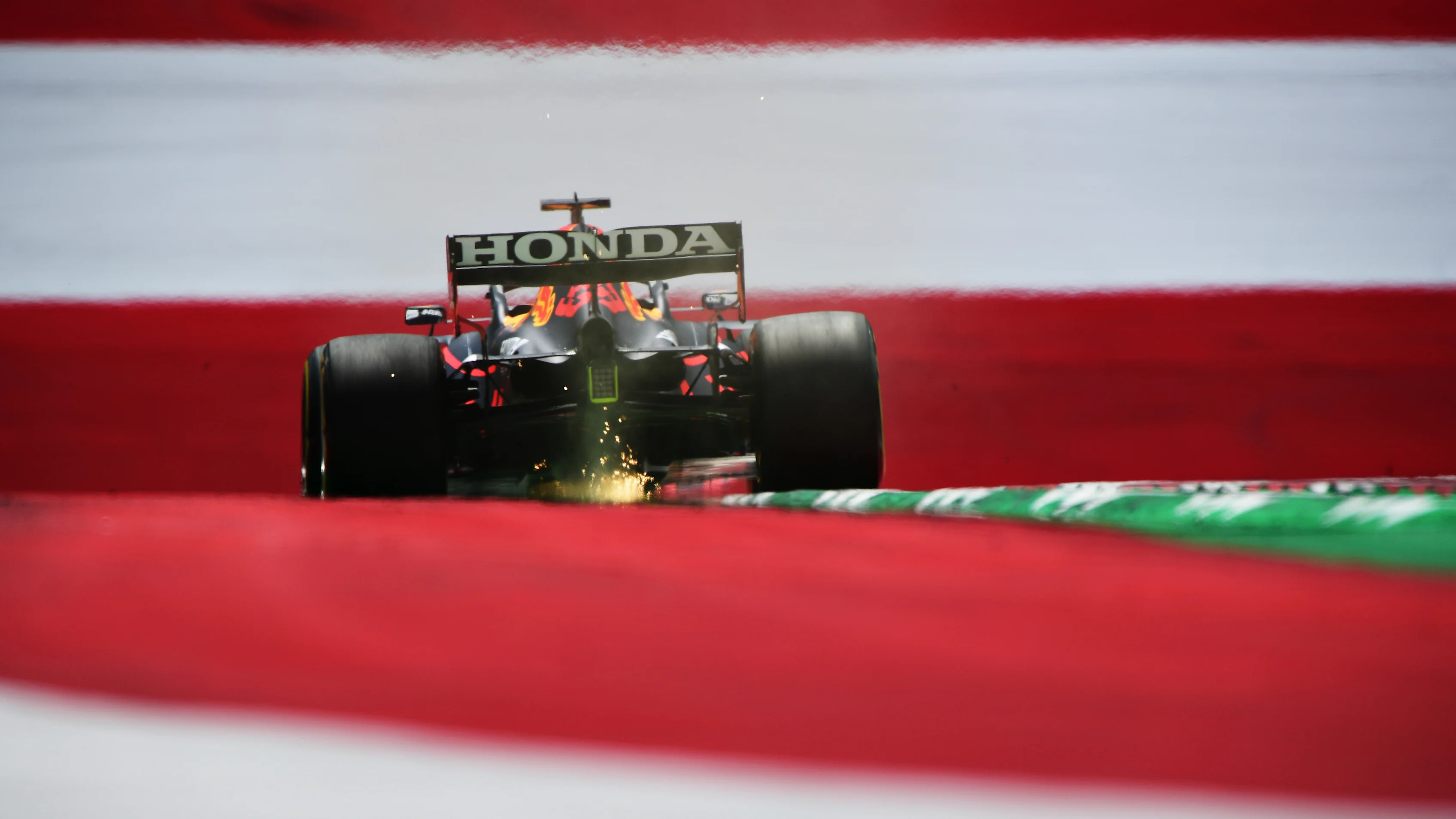 SPIELBERG, AUSTRIA - JUNE 25: Sparks fly behind Max Verstappen of the Netherlands driving the (33)