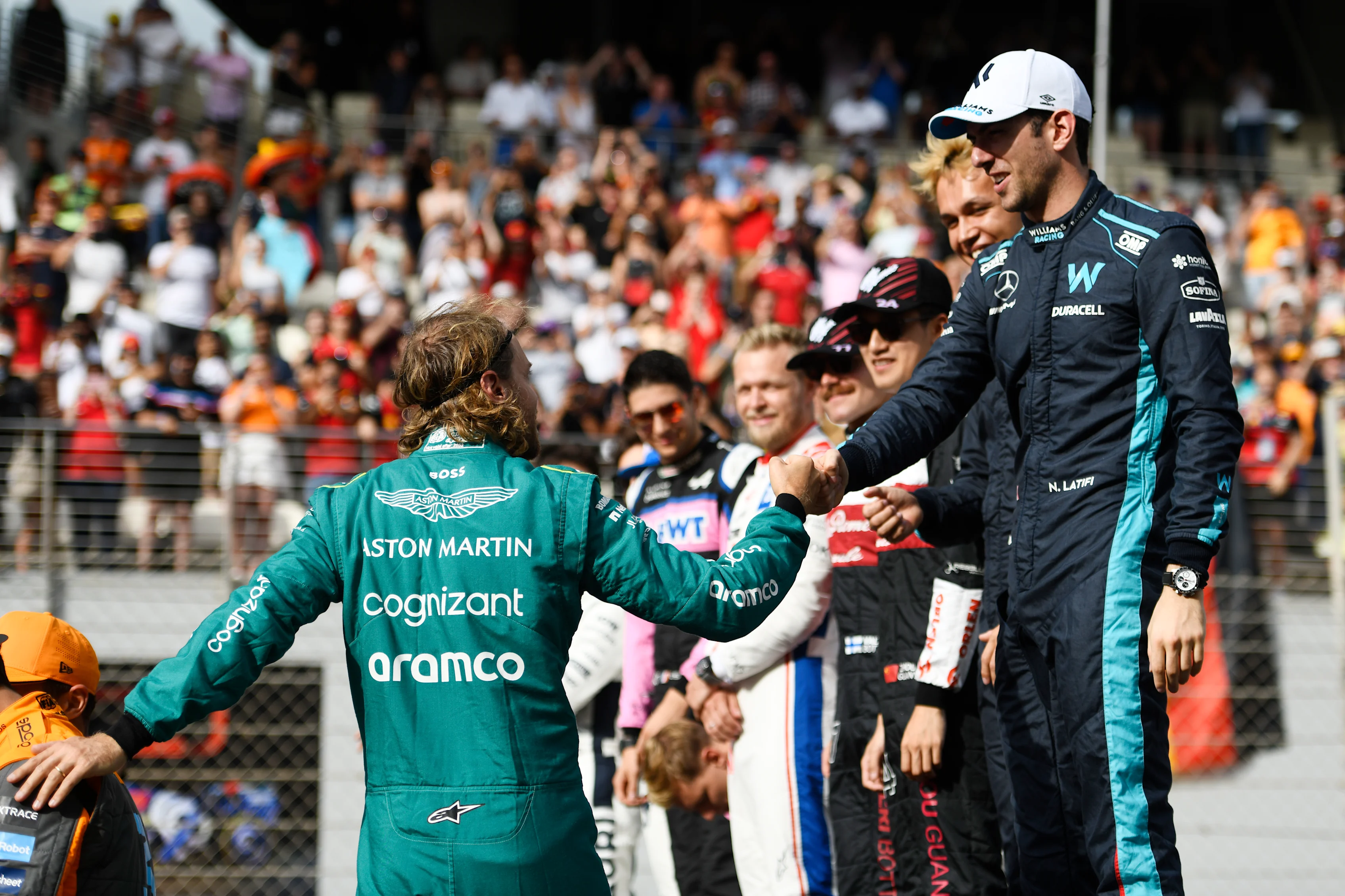ABU DHABI, UNITED ARAB EMIRATES - NOVEMBER 20: Sebastian Vettel of Germany and Aston Martin F1 Team is greeted by Nicholas Latifi of Canada and Williams  as they prepare for the F1 2022 End of Year photo prior to the F1 Grand Prix of Abu Dhabi at Yas Marina Circuit on November 20, 2022 in Abu Dhabi, United Arab Emirates. (Photo by Rudy Carezzevoli/Getty Images)