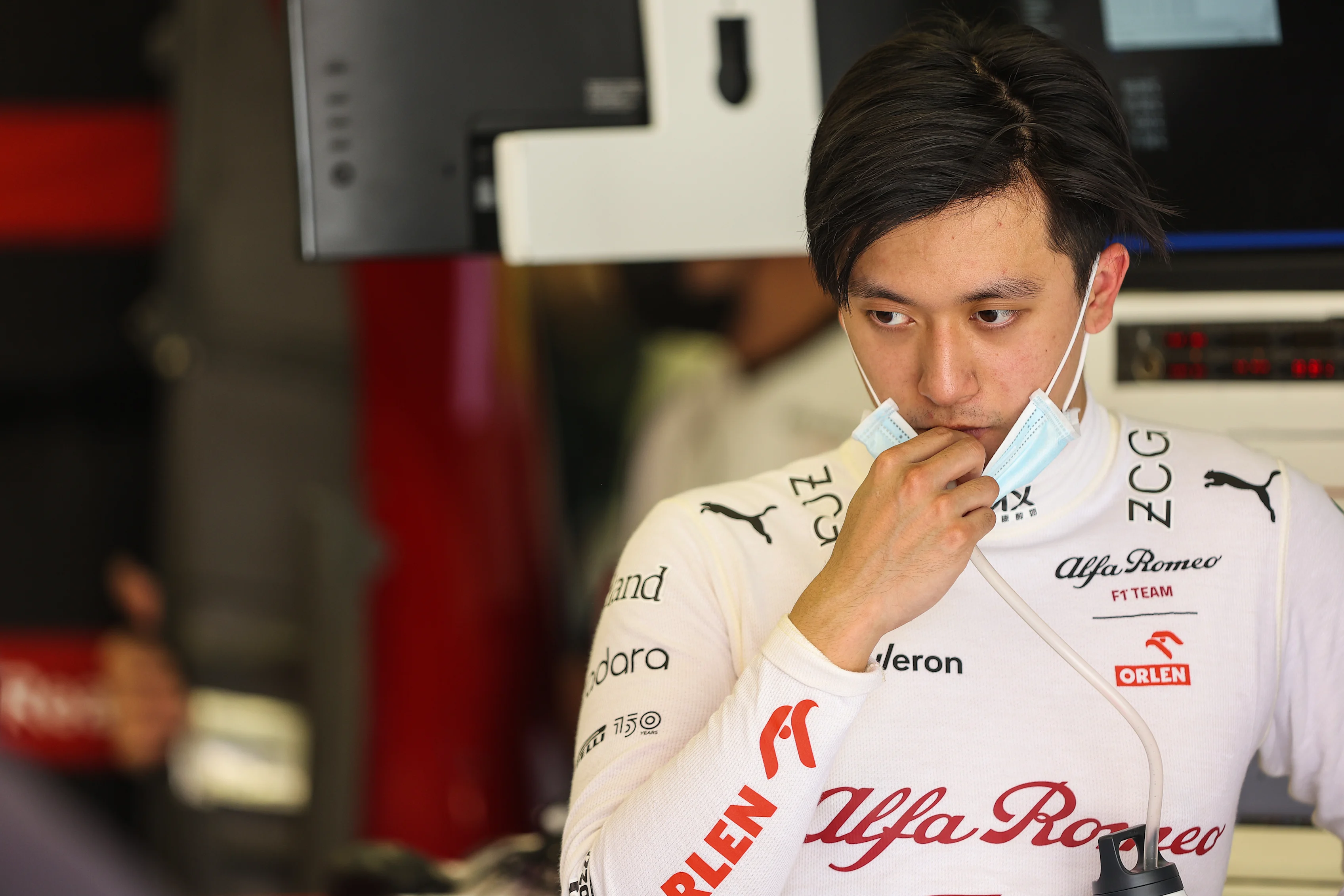 BAHRAIN, BAHRAIN - MARCH 10: Zhou Guanyu of China and Alfa Romeo F1 looks on in the garage during