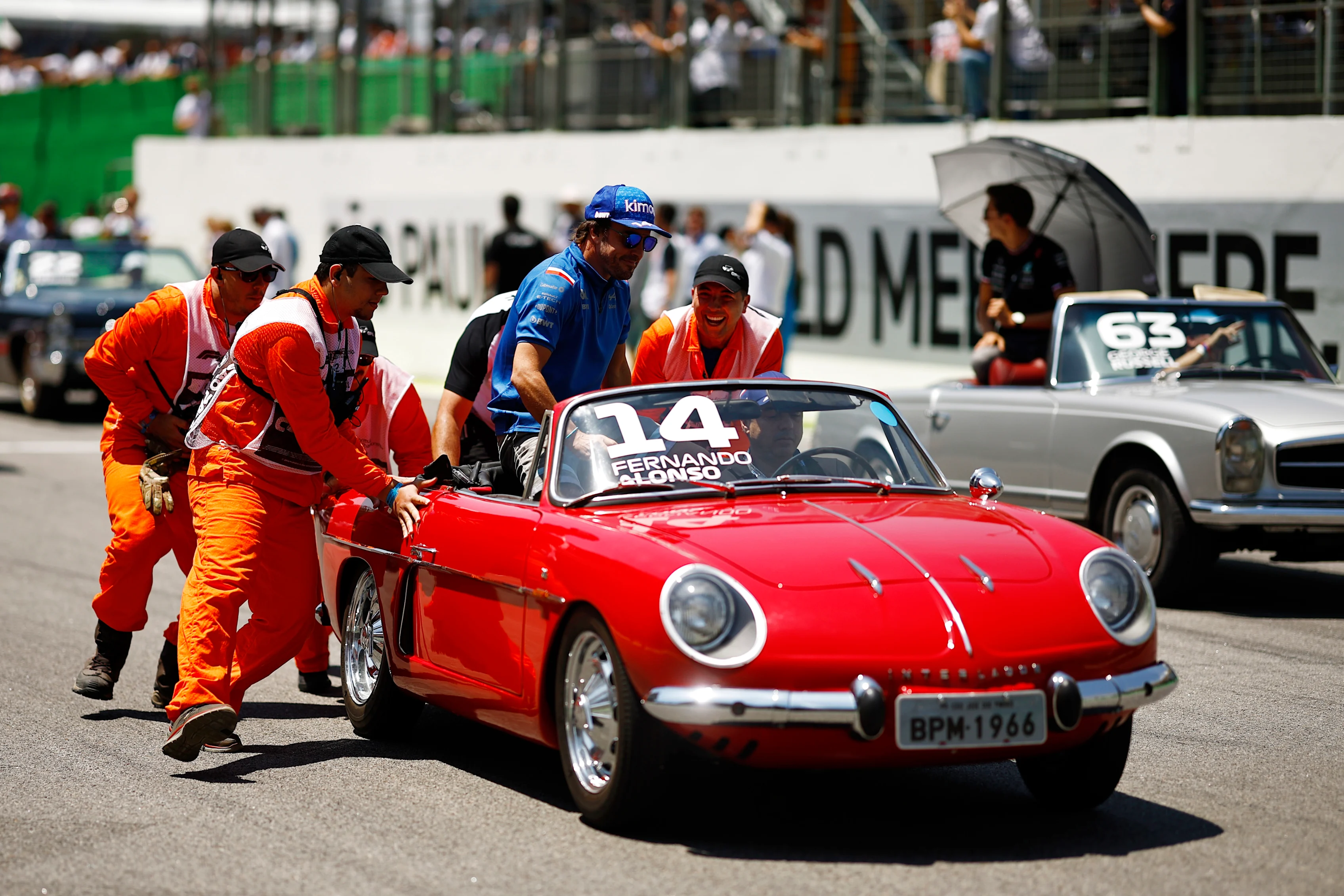 SAO PAULO, BRAZIL - NOVEMBER 13: Track marshals help Fernando Alonso of Spain and Alpine F1 as his car stops on the drivers parade prior to the F1 Grand Prix of Brazil at Autodromo Jose Carlos Pace on November 13, 2022 in Sao Paulo, Brazil. (Photo by Chris Graythen/Getty Images)