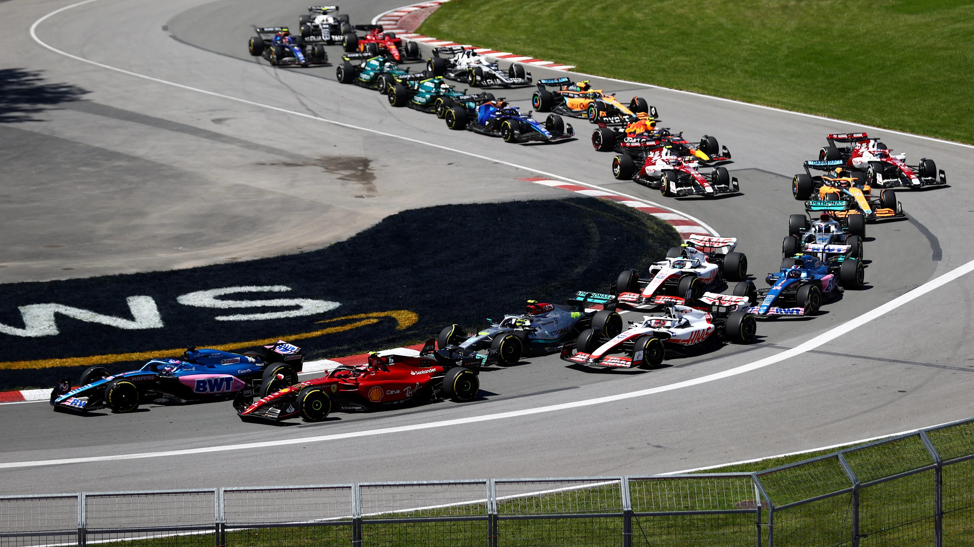 MONTREAL, QUEBEC - JUNE 19: Fernando Alonso of Spain driving the (14) Alpine F1 A522 Renault and Carlos Sainz of Spain driving (55) the Ferrari F1-75 battle for track position at the start during the F1 Grand Prix of Canada at Circuit Gilles Villeneuve on June 19, 2022 in Montreal, Quebec. (Photo by Dan Istitene - Formula 1/Formula 1 via Getty Images)