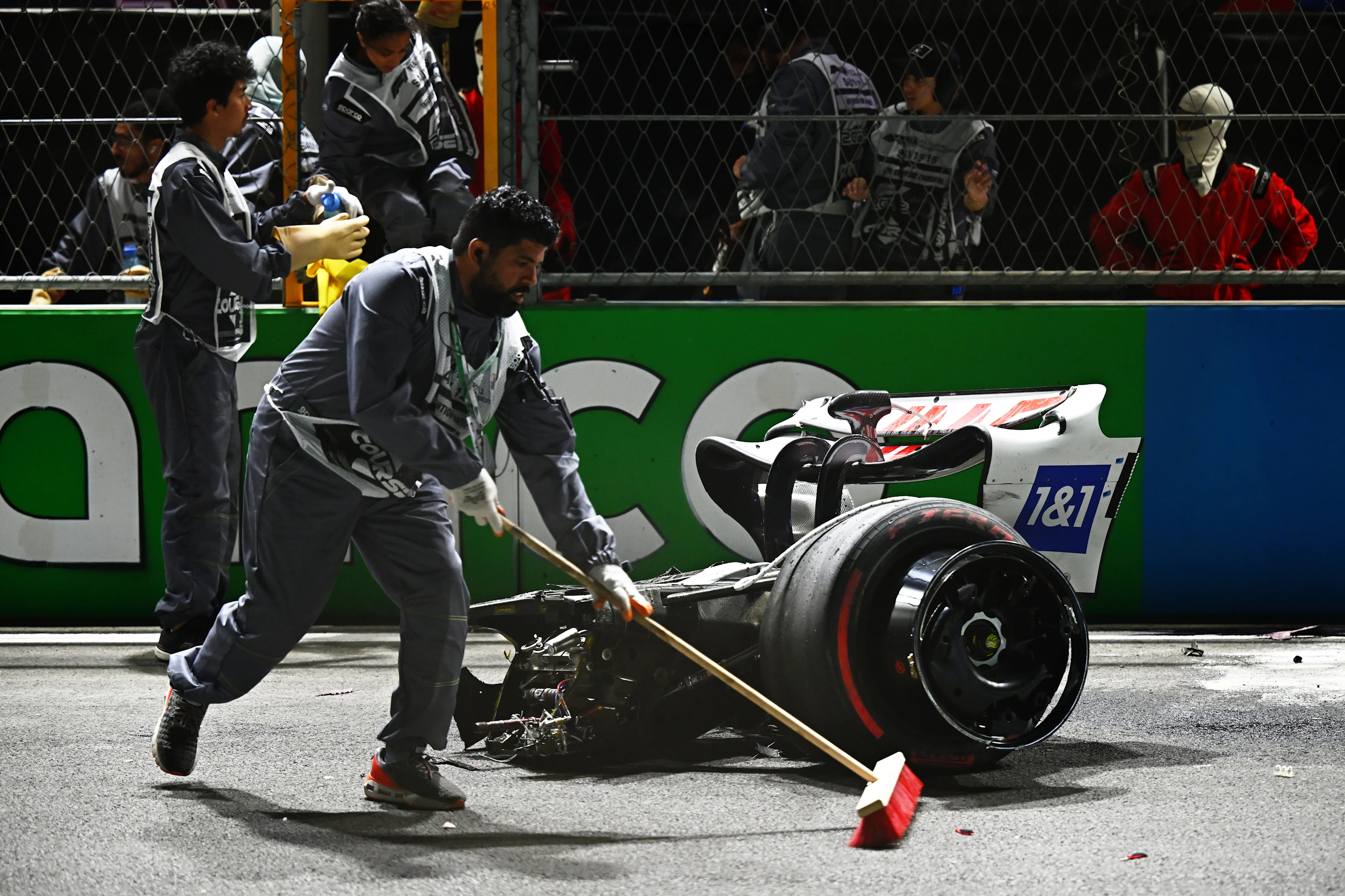 JEDDAH, SAUDI ARABIA - MARCH 26: Track marshals clean debris from the track following the crash of
