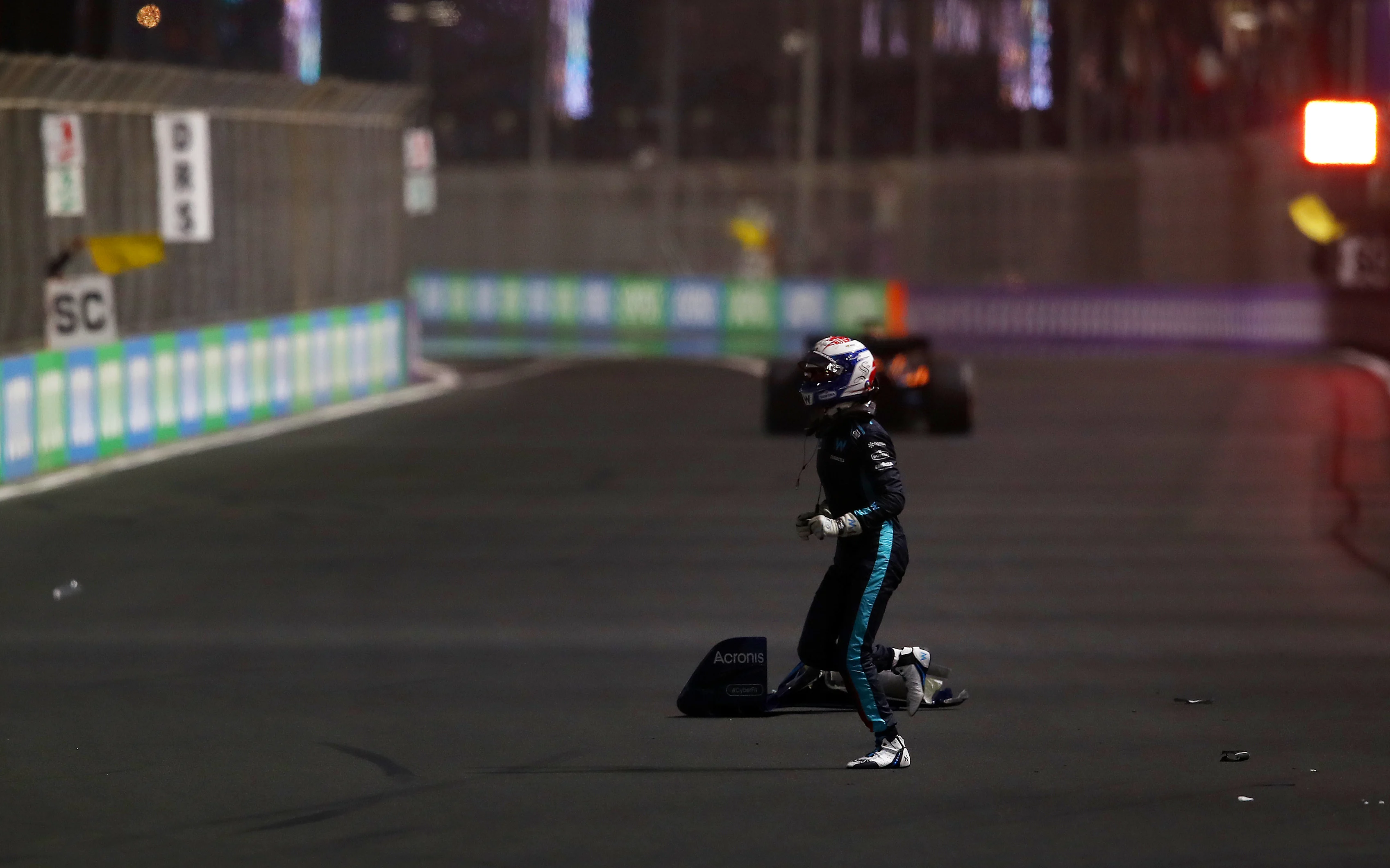JEDDAH, SAUDI ARABIA - MARCH 27: Nicholas Latifi of Canada and Williams runs across the track after crashing during the F1 Grand Prix of Saudi Arabia at the Jeddah Corniche Circuit on March 27, 2022 in Jeddah, Saudi Arabia. (Photo by Joe Portlock - Formula 1/Formula 1 via Getty Images)