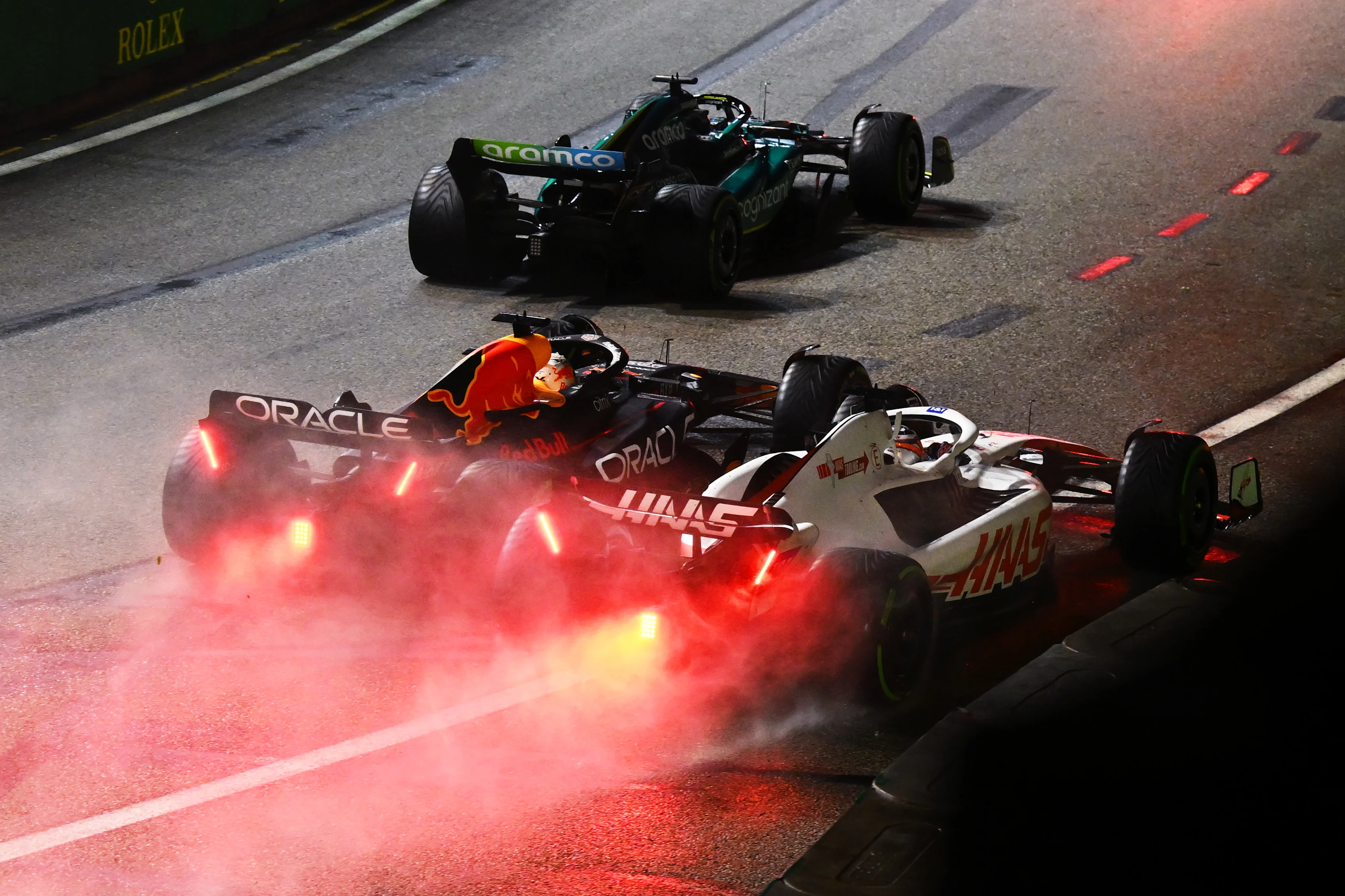 SINGAPORE, SINGAPORE - OCTOBER 02: Max Verstappen of the Netherlands driving the (1) Oracle Red Bull Racing RB18 and Kevin Magnussen of Denmark driving the (20) Haas F1 VF-22 Ferrari battle for track position during the F1 Grand Prix of Singapore at Marina Bay Street Circuit on October 02, 2022 in Singapore, Singapore. (Photo by Clive Mason/Getty Images,)