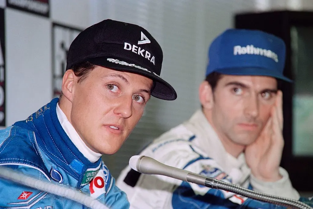 German driver Michael Schumacher (L) speaks to reporters after grabbing the pole position of the