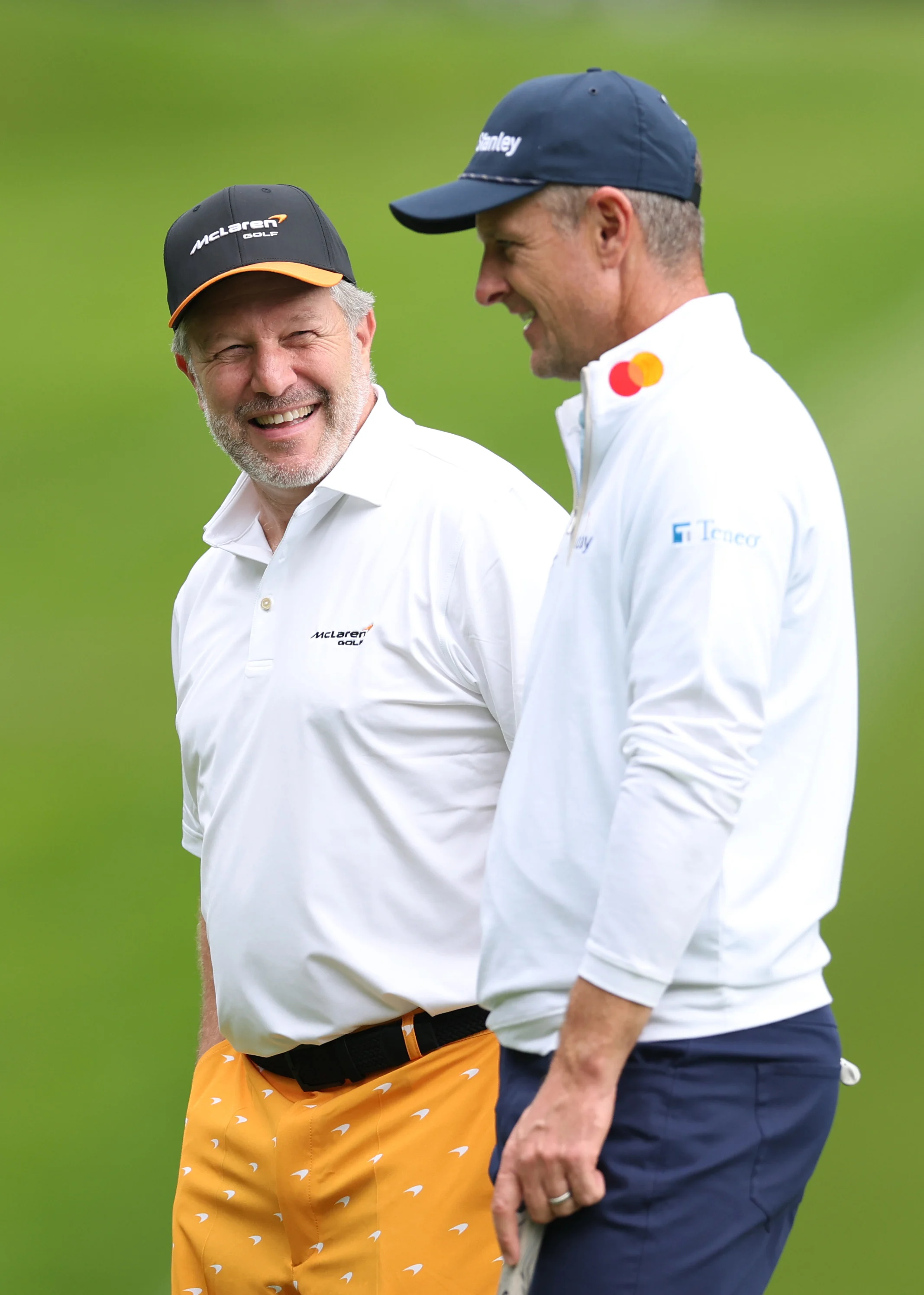 VIRGINIA WATER, ENGLAND - SEPTEMBER 16: Zak Brown interacts with Justin Rose of England during the