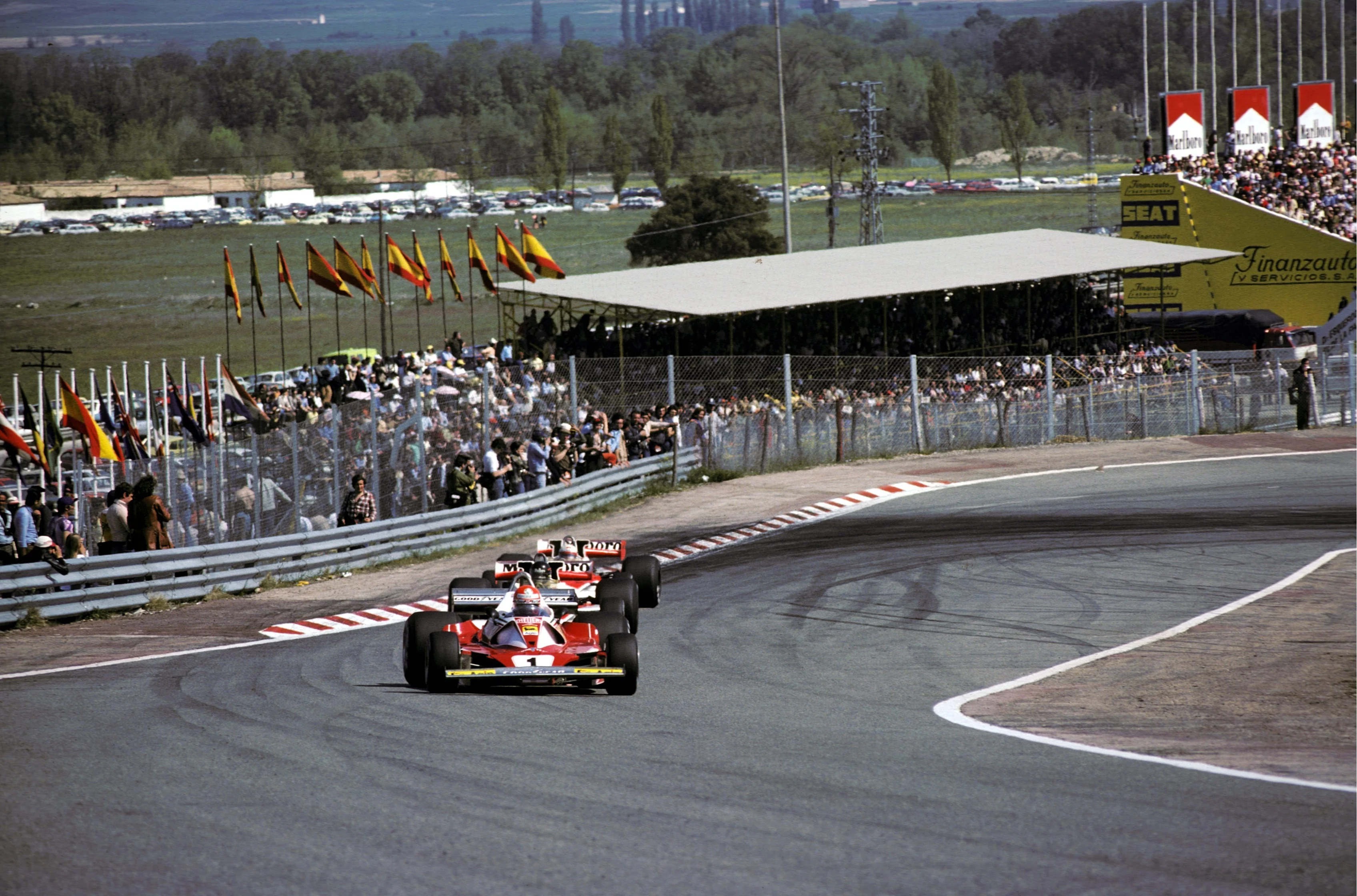 Second placed Niki Lauda (AUT) Ferrari 312T2 leads James Hunt (GBR) McLaren M23, who won, was then
