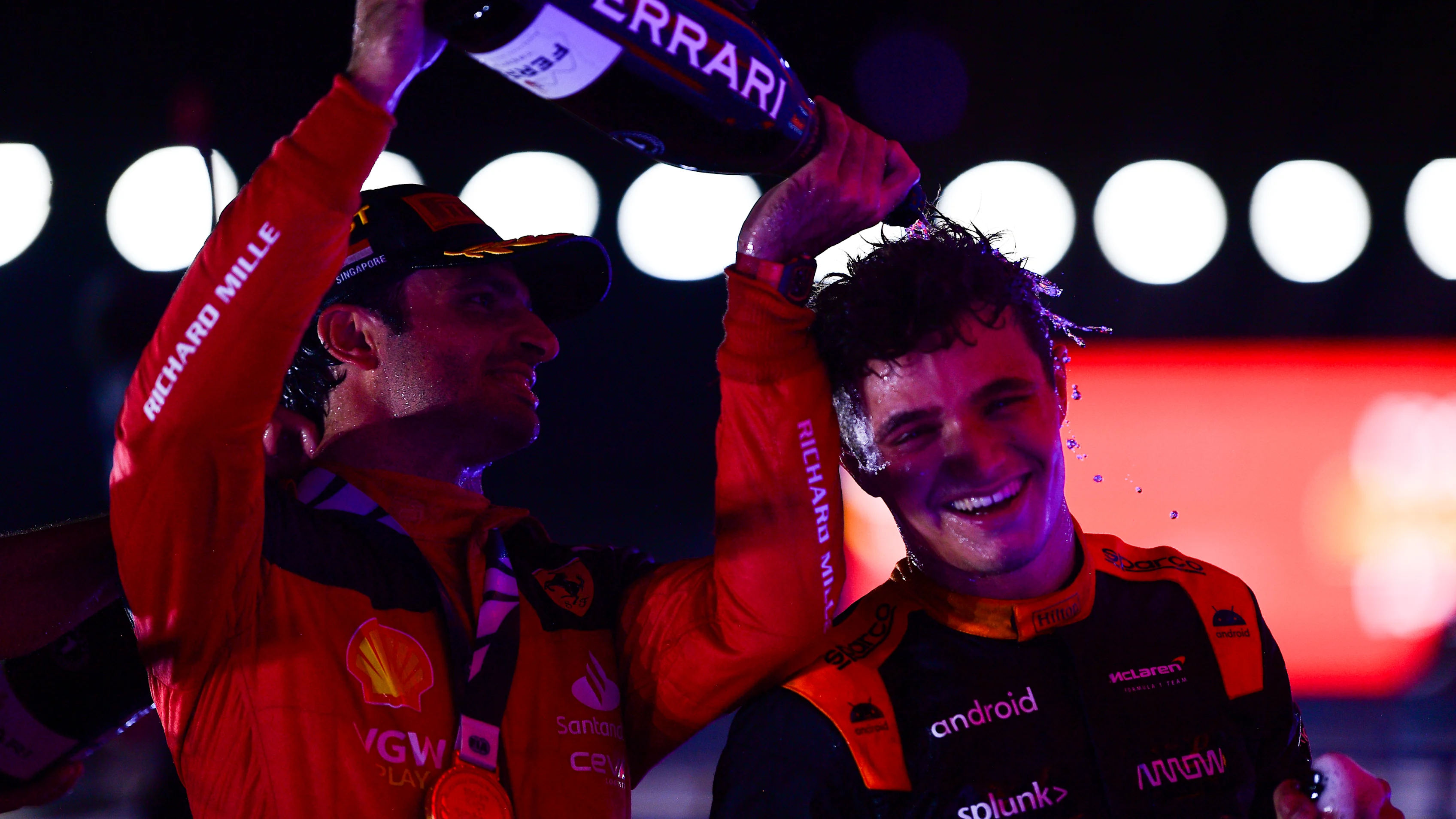 SINGAPORE, SINGAPORE - SEPTEMBER 17: Race winner Carlos Sainz of Spain and Ferrari celebrates with Second placed Lando Norris of Great Britain and McLaren on the podium during the F1 Grand Prix of Singapore at Marina Bay Street Circuit on September 17, 2023 in Singapore, Singapore. (Photo by Mario Renzi - Formula 1/Formula 1 via Getty Images)