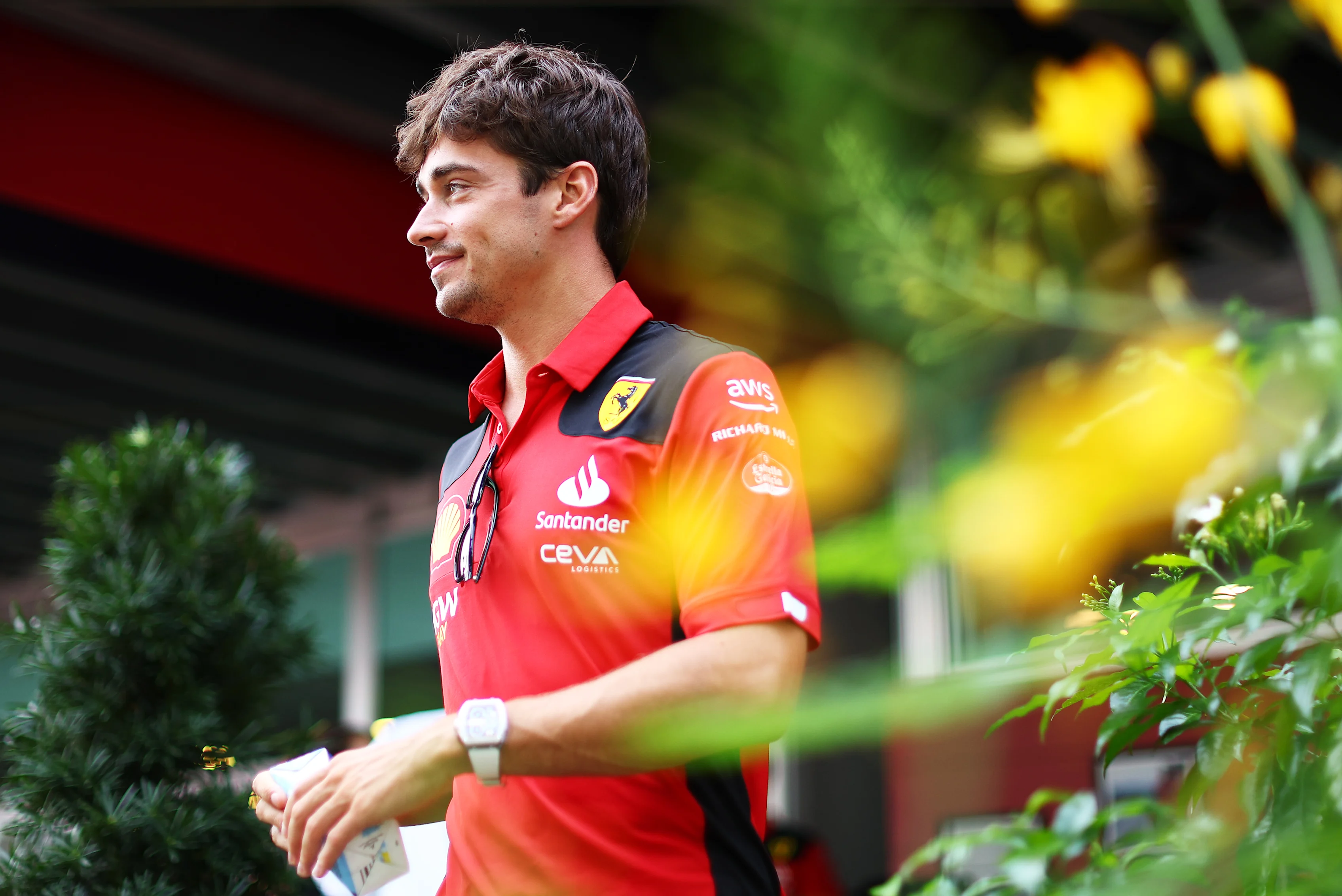 SINGAPORE, SINGAPORE - SEPTEMBER 14: Charles Leclerc of Monaco and Ferrari walks in the Paddock