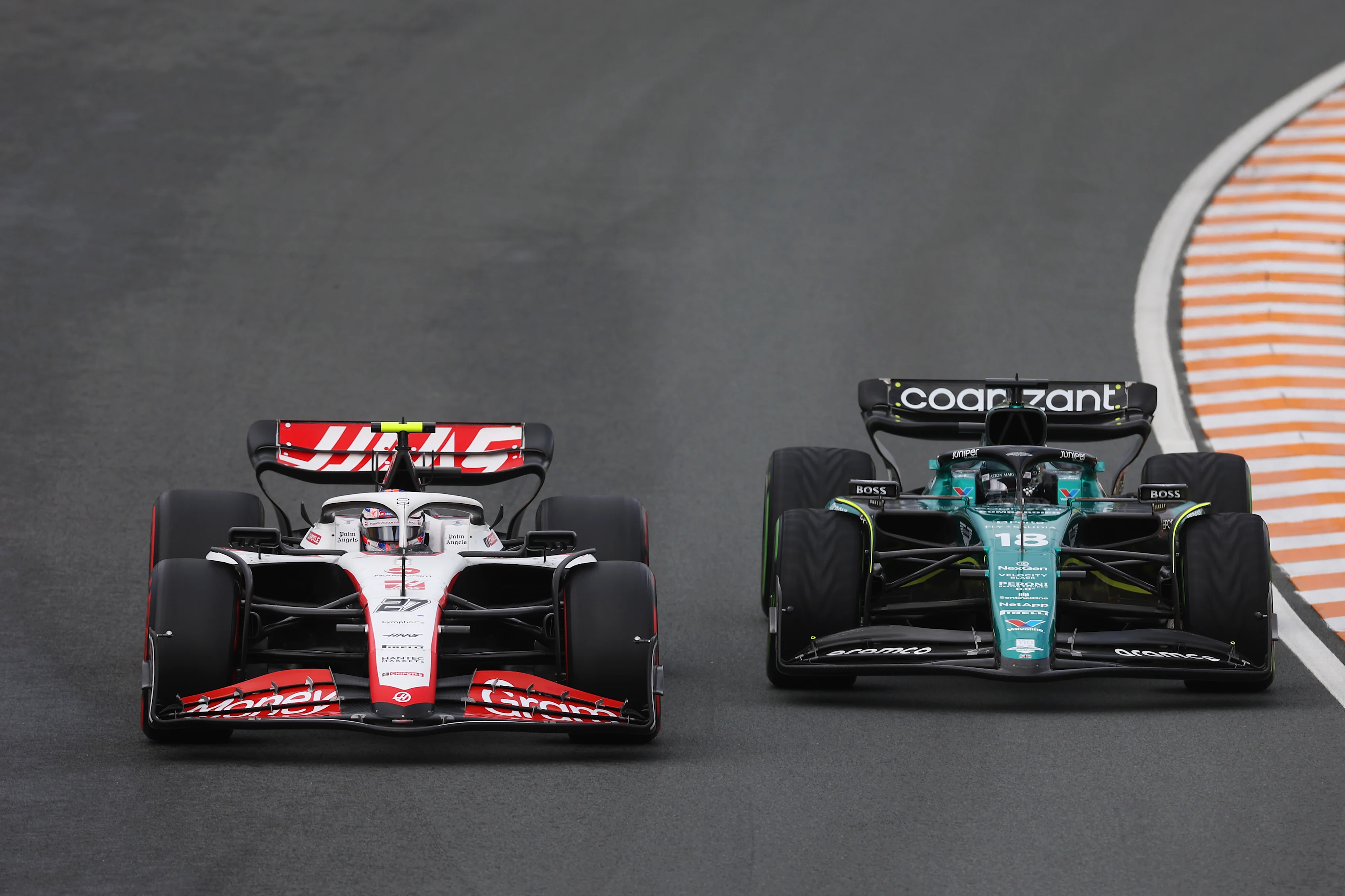 ZANDVOORT, NETHERLANDS - AUGUST 27: Nico Hulkenberg of Germany driving the (27) Haas F1 VF-23 Ferrari and Lance Stroll of Canada driving the (18) Aston Martin AMR23 Mercedes battle for track position during the F1 Grand Prix of The Netherlands at Circuit Zandvoort on August 27, 2023 in Zandvoort, Netherlands. (Photo by Lars Baron/Getty Images)