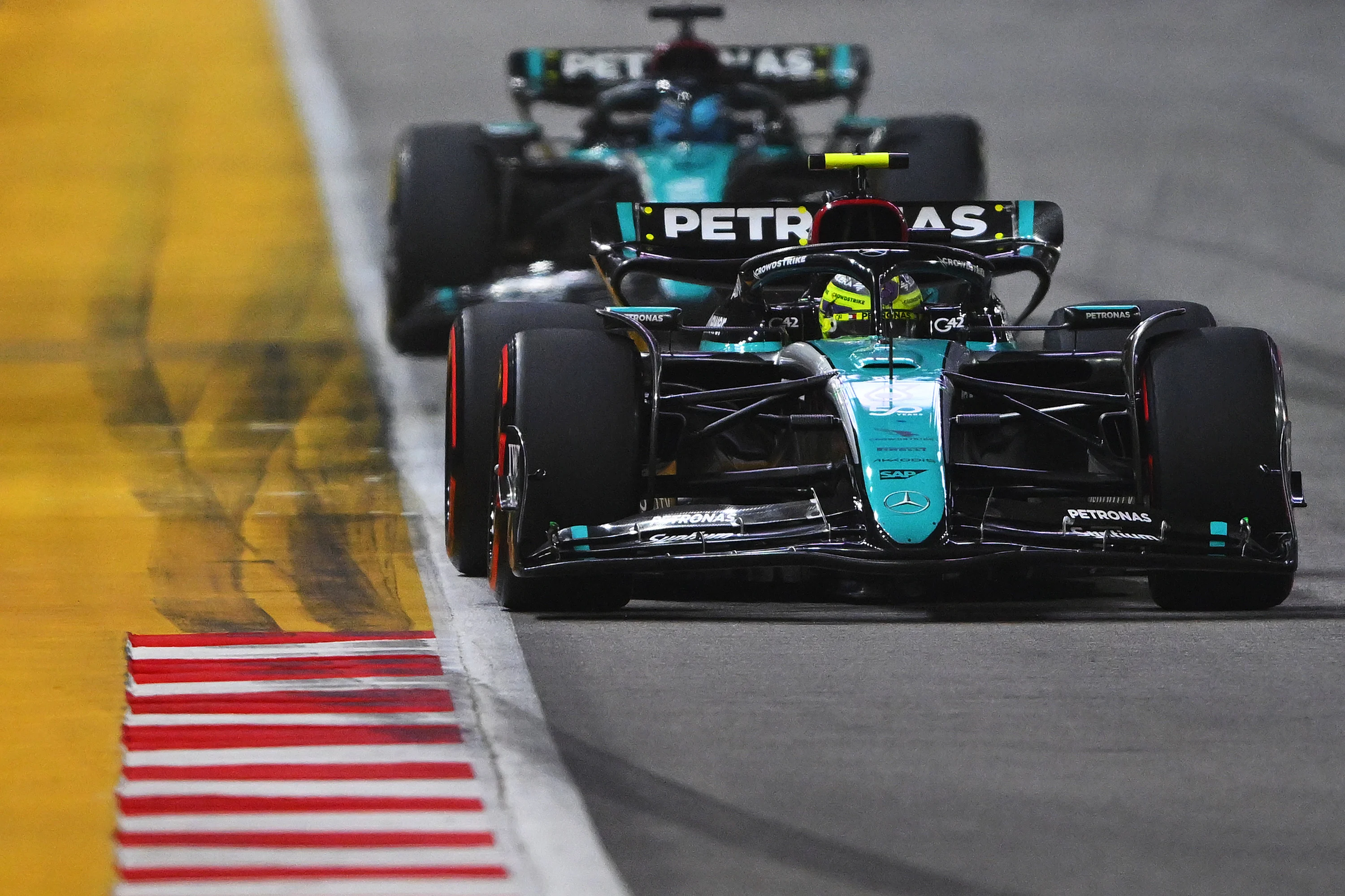 SINGAPORE, SINGAPORE - SEPTEMBER 22: Lewis Hamilton of Great Britain driving the (44) Mercedes AMG Petronas F1 Team W15 leads George Russell of Great Britain driving the (63) Mercedes AMG Petronas F1 Team W15 on track during the F1 Grand Prix of Singapore at Marina Bay Street Circuit on September 22, 2024 in Singapore, Singapore. (Photo by Rudy Carezzevoli/Getty Images)