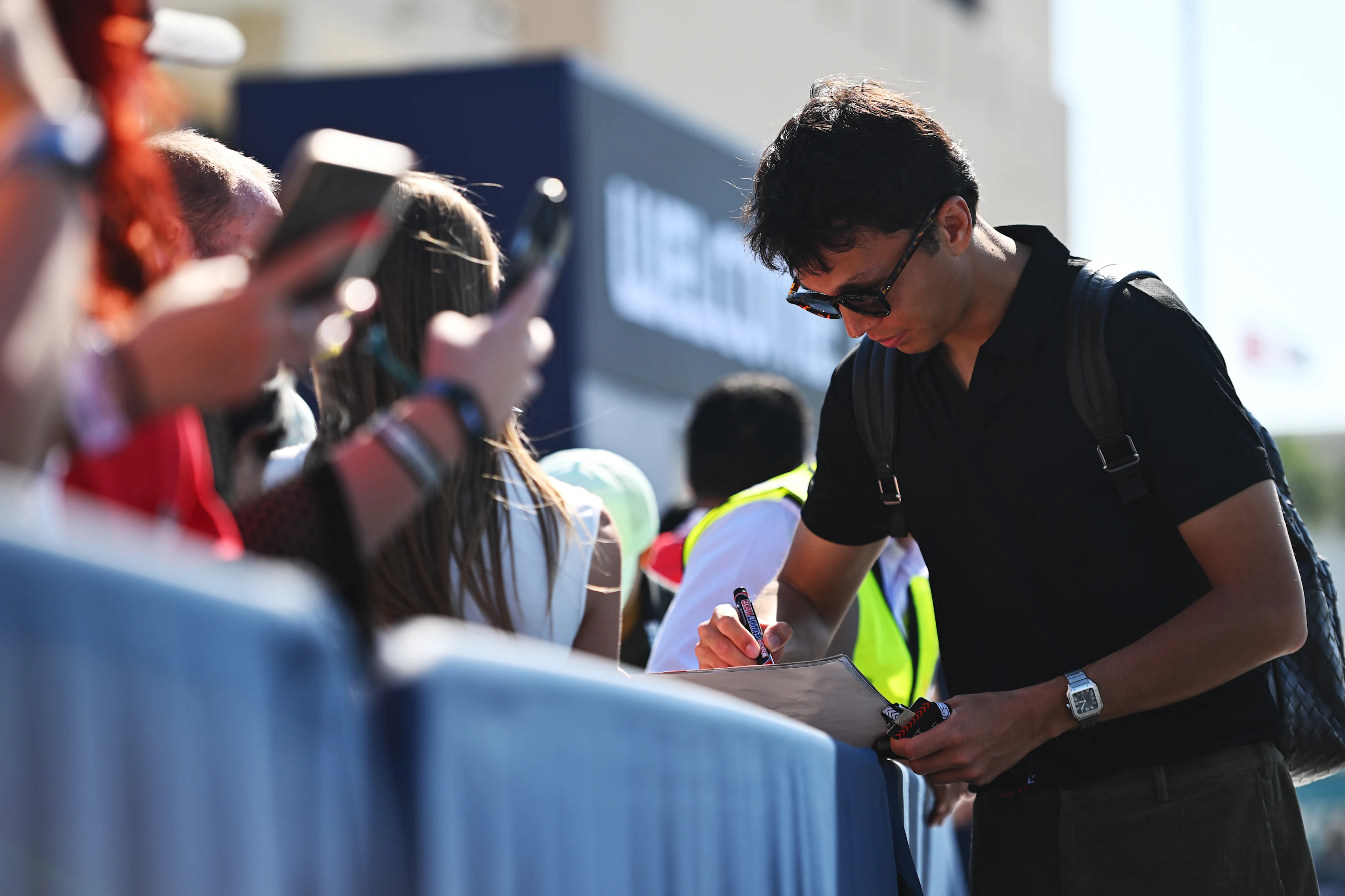ABU DHABI, UNITED ARAB EMIRATES - DECEMBER 08: Alexander Albon of Thailand and Williams signs autographs for fans in the Paddock prior to the F1 Grand Prix of Abu Dhabi at Yas Marina Circuit on December 08, 2024 in Abu Dhabi, United Arab Emirates. (Photo by Rudy Carezzevoli/Getty Images)