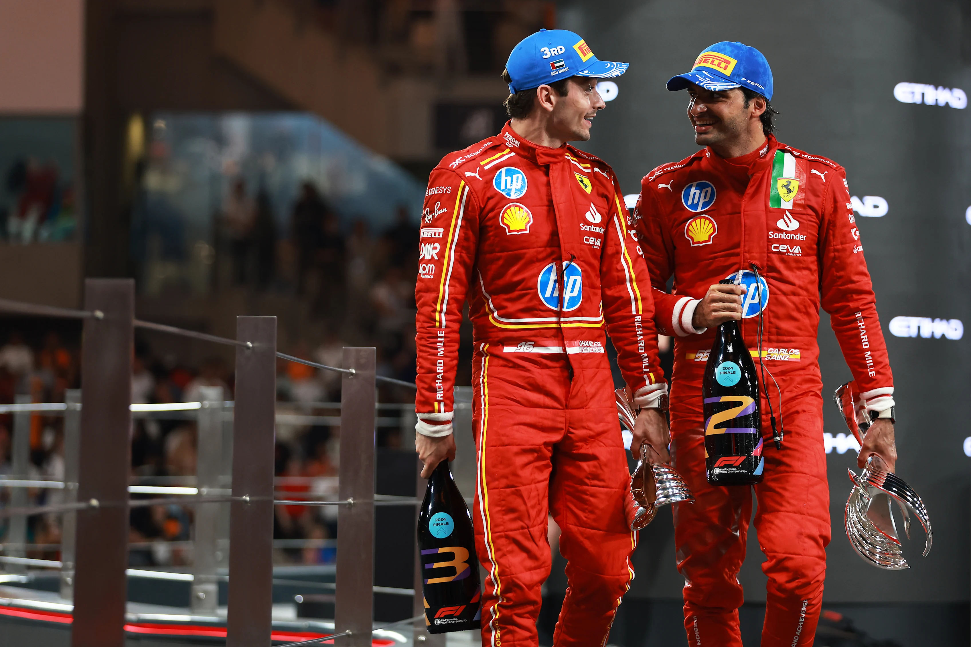 ABU DHABI, UNITED ARAB EMIRATES - DECEMBER 08: Second placed Carlos Sainz of Spain and Ferrari and Third placed Charles Leclerc of Monaco and Ferrari celebrate on the podium during the F1 Grand Prix of Abu Dhabi at Yas Marina Circuit on December 08, 2024 in Abu Dhabi, United Arab Emirates. (Photo by Bryn Lennon - Formula 1/Formula 1 via Getty Images)