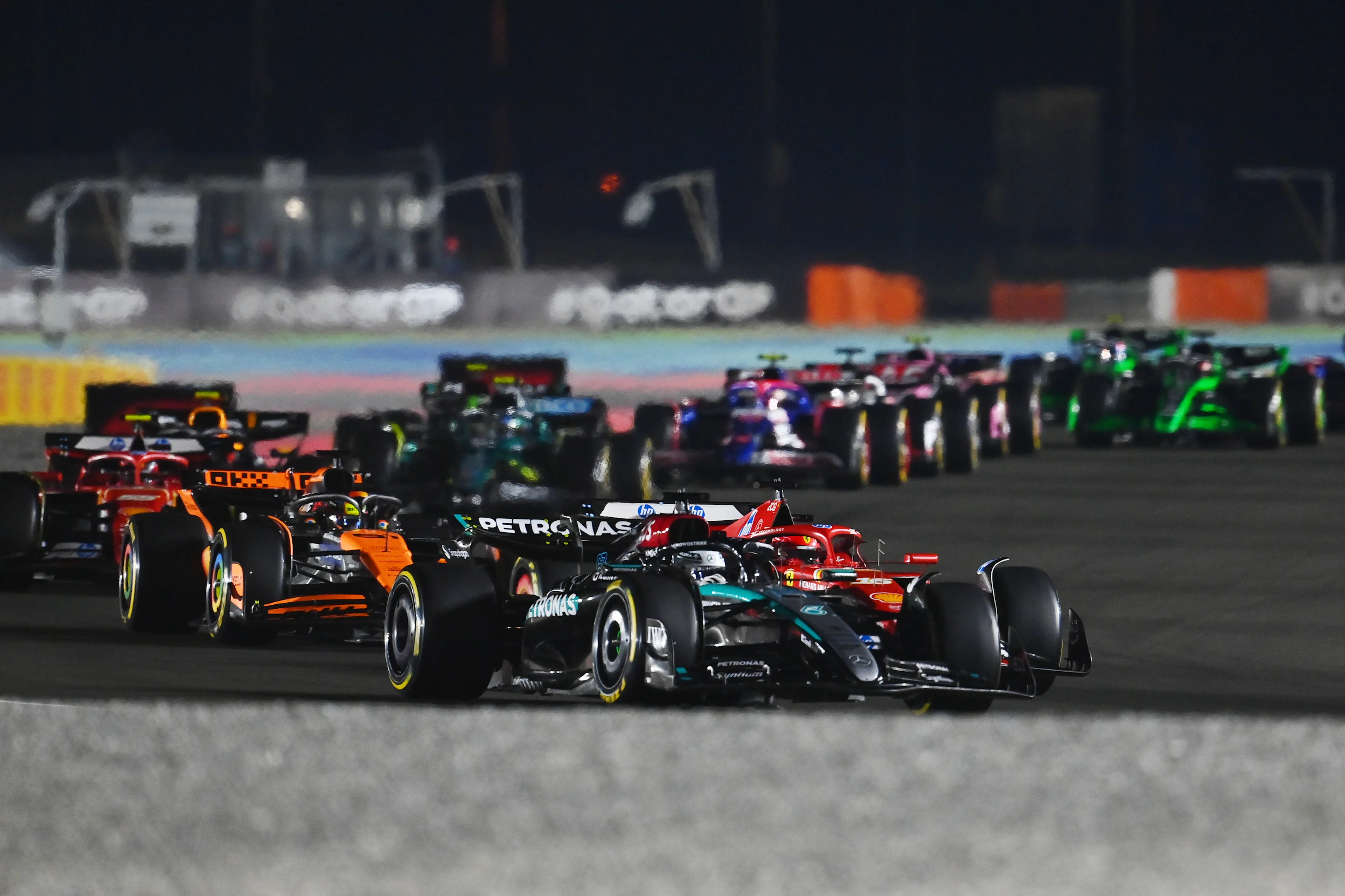 LUSAIL CITY, QATAR - DECEMBER 01: George Russell of Great Britain driving the (63) Mercedes AMG Petronas F1 Team W15 leads Charles Leclerc of Monaco driving the (16) Ferrari SF-24 on track during the F1 Grand Prix of Qatar at Lusail International Circuit on December 01, 2024 in Lusail City, Qatar. (Photo by James Sutton - Formula 1/Formula 1 via Getty Images)