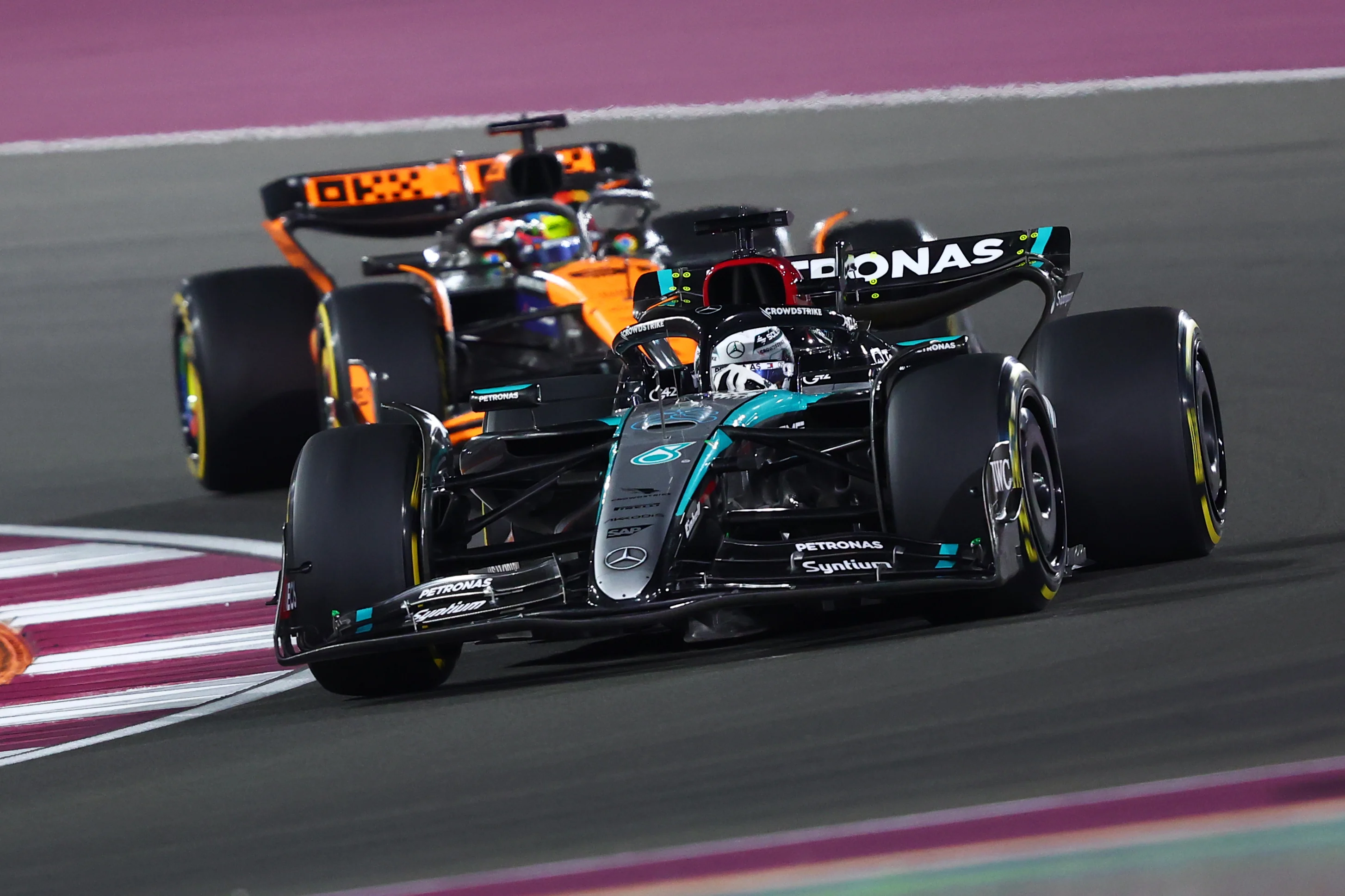 George Russell leads Oscar Piastri of Australia driving the (81) McLaren MCL38 Mercedes on track during the F1 Grand Prix of Qatar at Lusail International Circuit on December 01, 2024 in Lusail City, Qatar. (Photo by Joe Portlock/Getty Images)