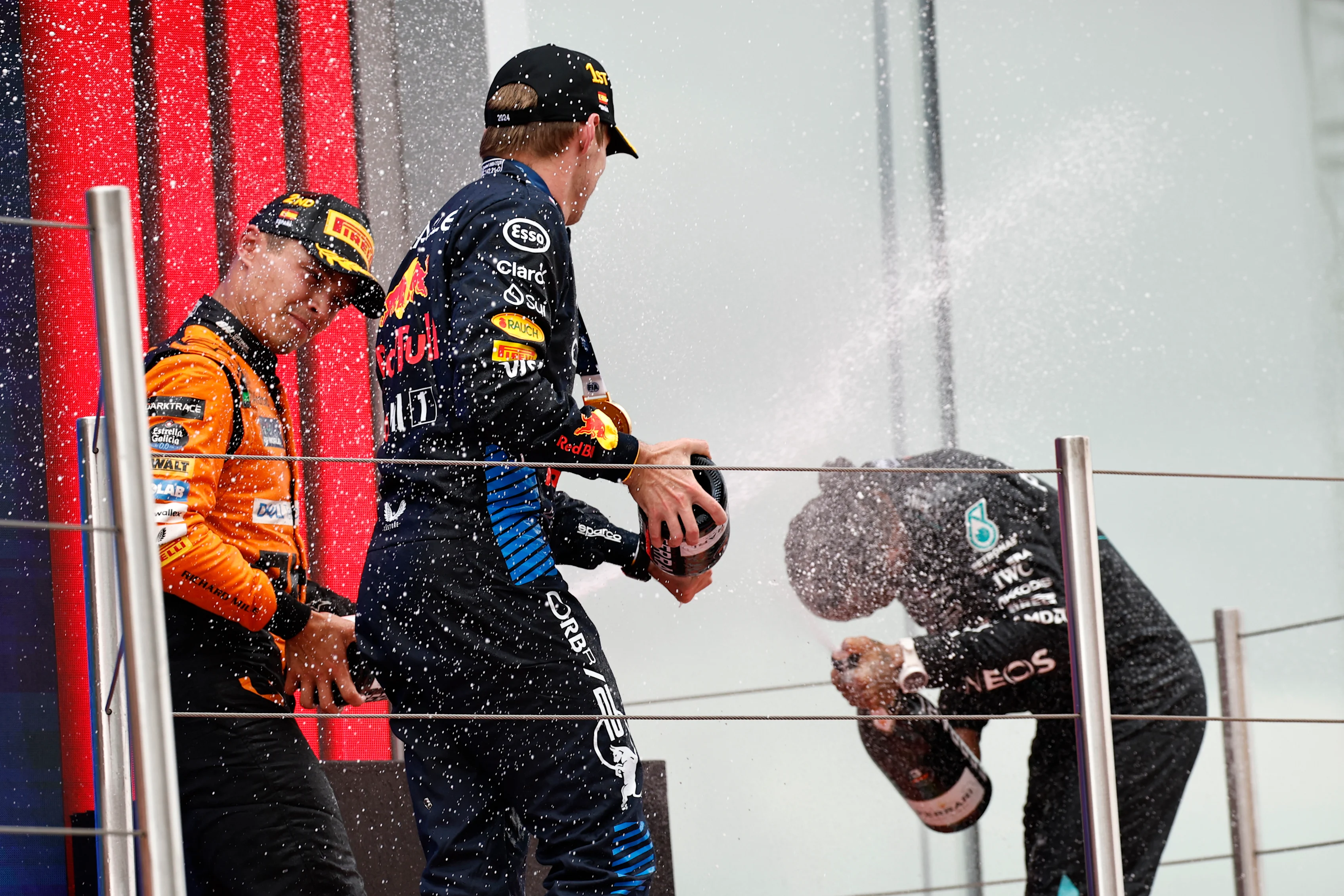 BARCELONA, SPAIN - JUNE 23: Race winner Max Verstappen of the Netherlands and Oracle Red Bull Racing, Second placed Lando Norris of Great Britain and McLaren, and Third placed Lewis Hamilton of Great Britain and Mercedes celebrate on the podium during the F1 Grand Prix of Spain at Circuit de Barcelona-Catalunya on June 23, 2024 in Barcelona, Spain. (Photo by Chris Graythen/Getty Images)