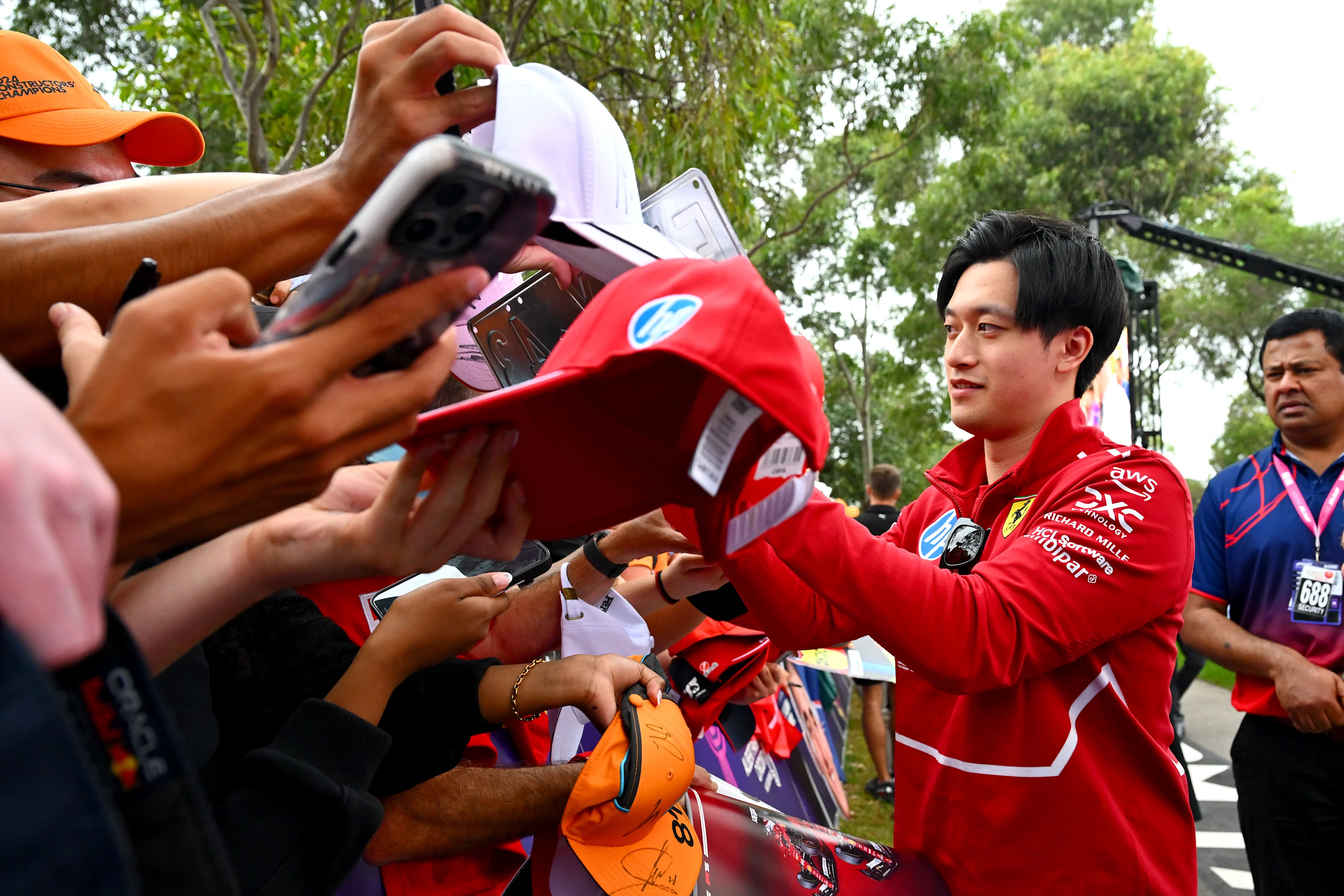 MELBOURNE, AUSTRALIA - MARCH 13: Zhou Guanyu of China and Scuderia Ferrari signs autographs for