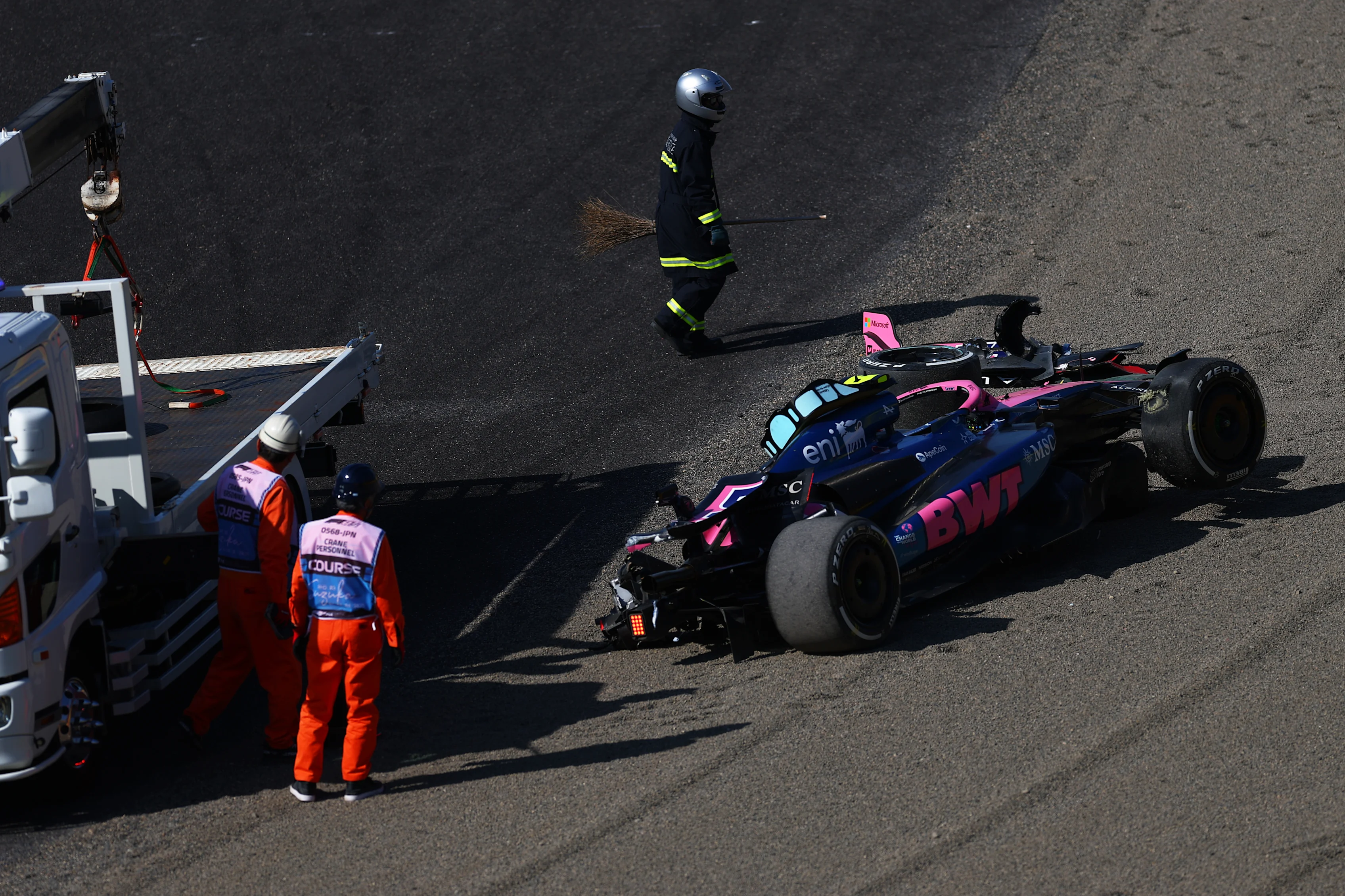 SUZUKA, JAPAN - APRIL 04: Marshals remove the damaged car of Jack Doohan of Australia driving the (7) Alpine F1 A525 Renault from the circuit after a crash during practice ahead of the F1 Grand Prix of Japan at Suzuka Circuit on April 04, 2025 in Suzuka, Japan. (Photo by Bryn Lennon - Formula 1/Formula 1 via Getty Images)